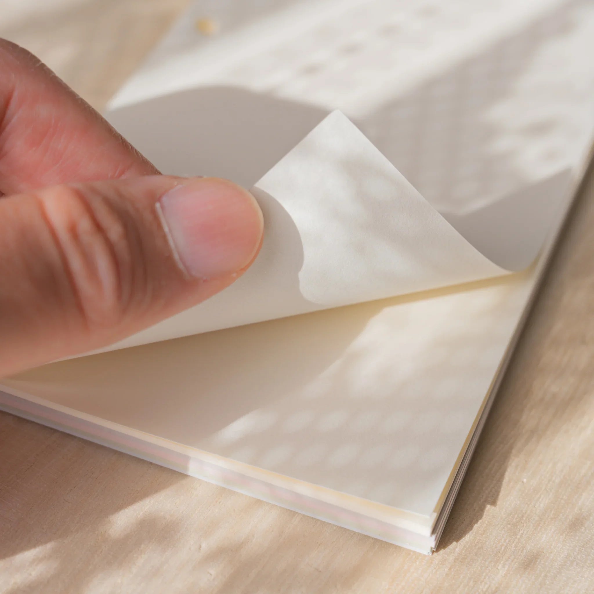 Hand peeling a translucent natural Araveal planner refill sheet from the Bible-size pack.