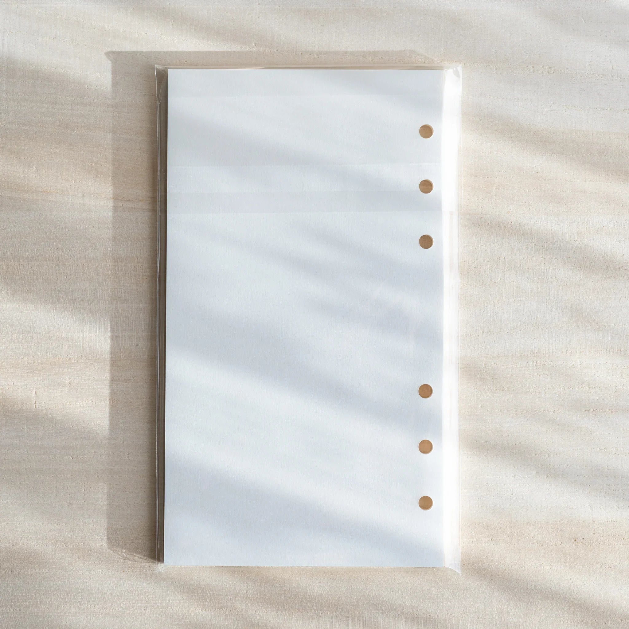 Japanese Stationery Bank Paper refill in clear packaging, showing crisp white Bible-size sheets with six-hole punches.