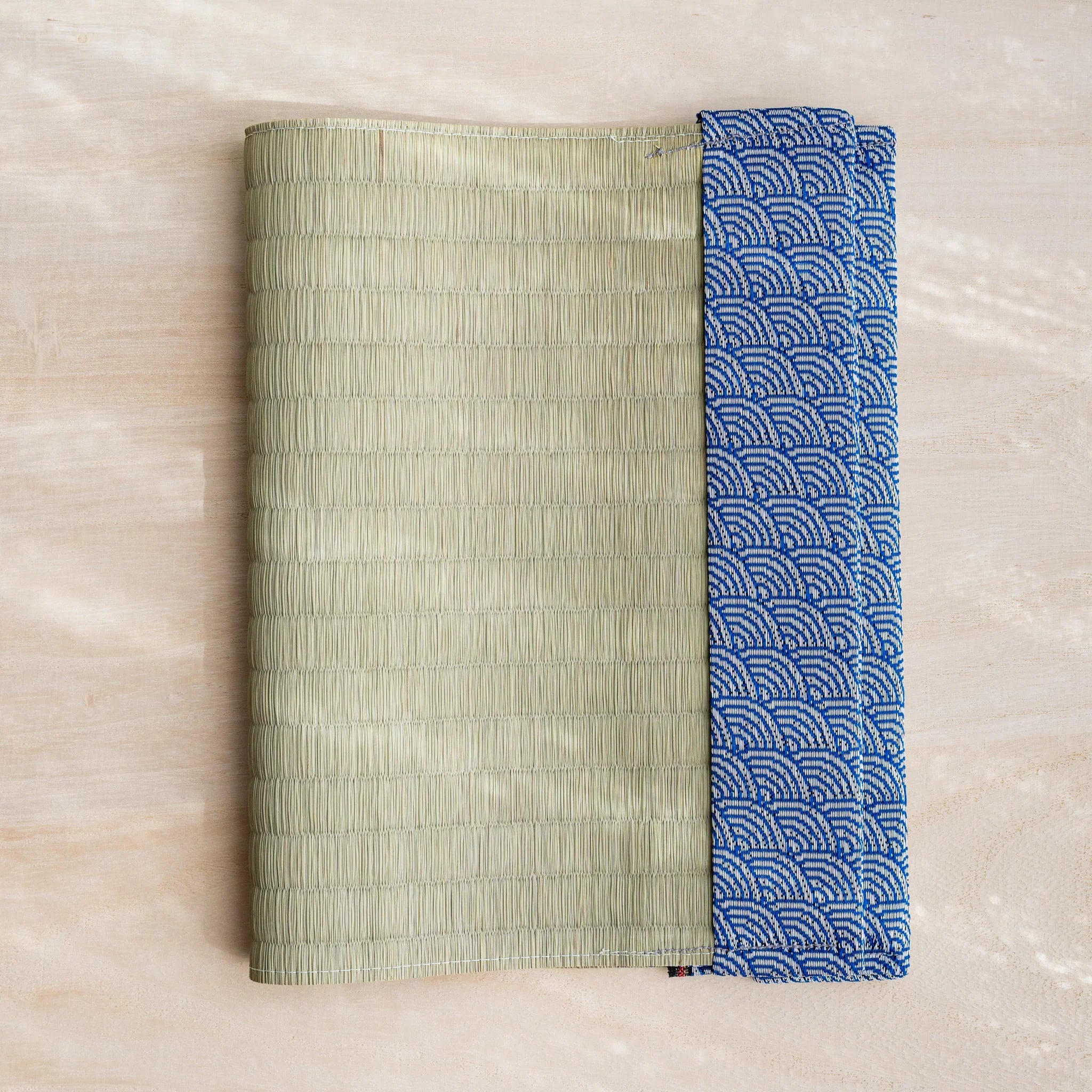 Blue Yachiyo tatami book cover closed, woven green rush straw with blue and white Japanese wave pattern fabric band