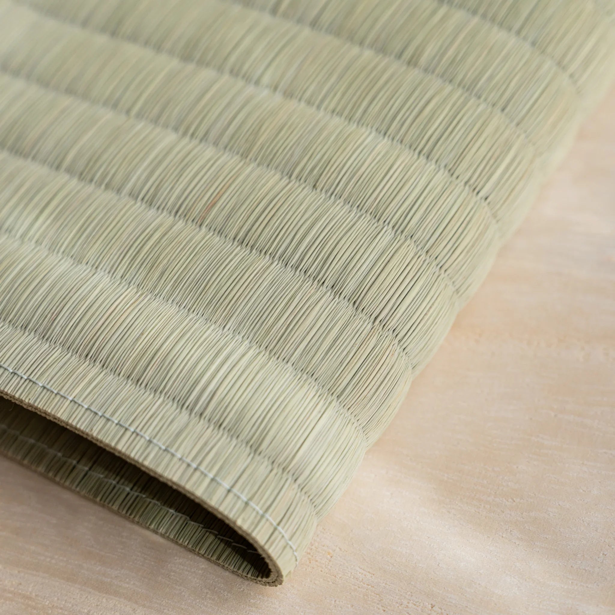 Close-up of the woven green rush straw surface of the Blue Yachiyo tatami book cover showing stitched rows