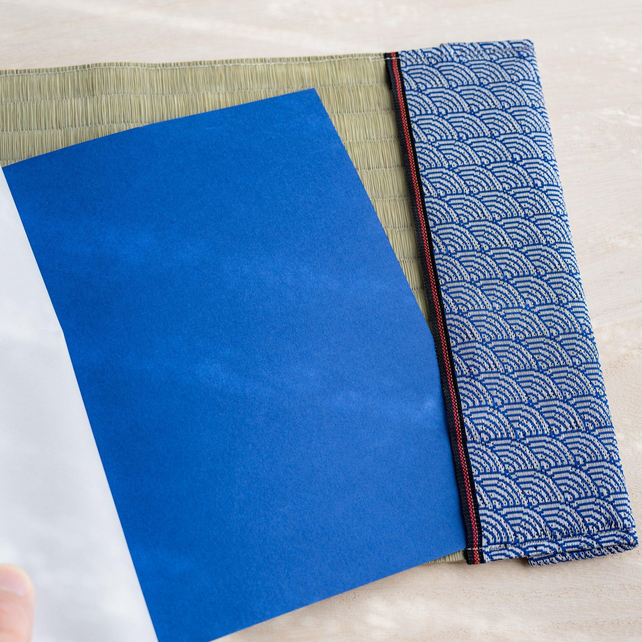 Tatami book cover inner flap open showing a blue notebook cover and blue and white wave pattern fabric band