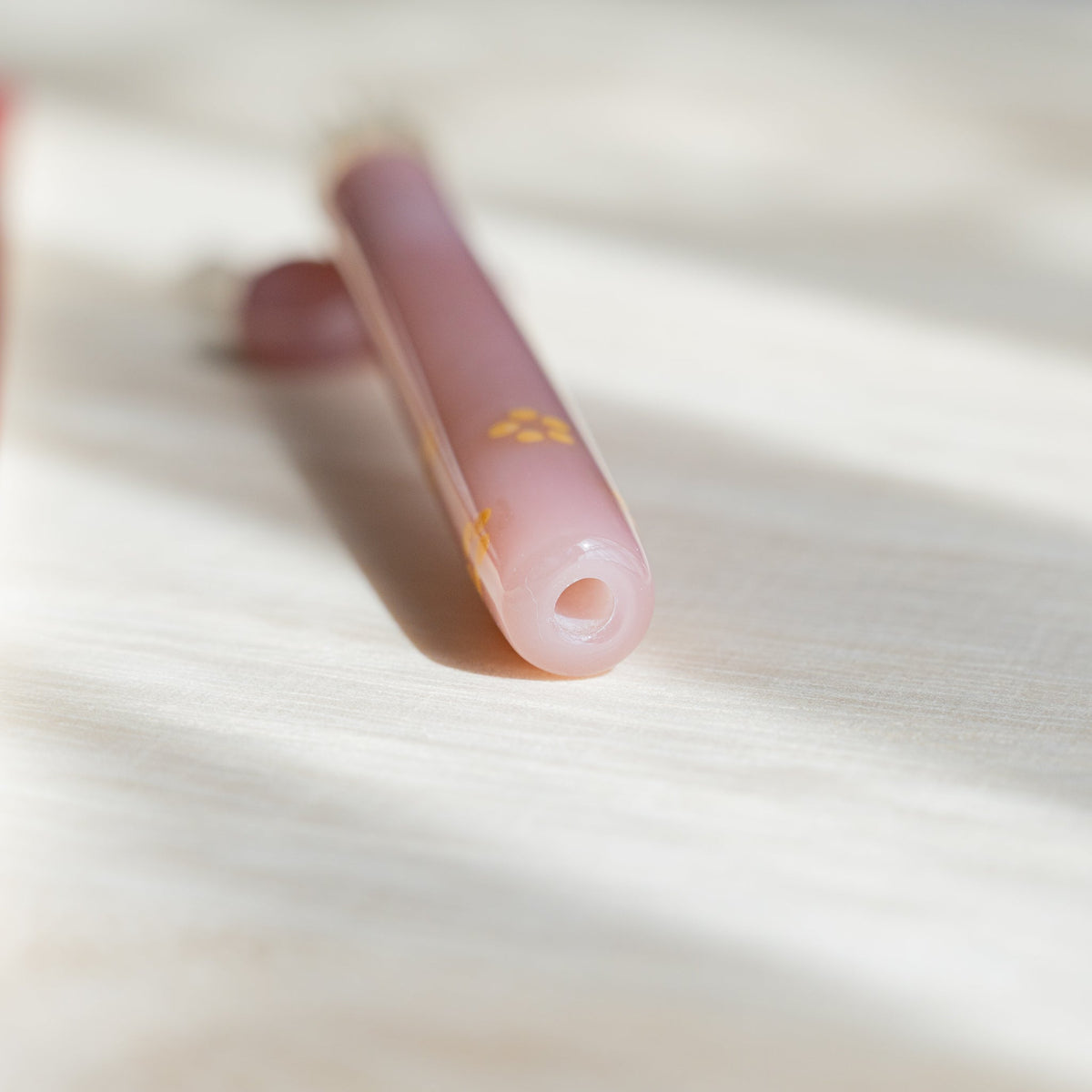 Close-up of the open end of the Blush Pink Flowers pen barrel showing the hollow pink glass tube