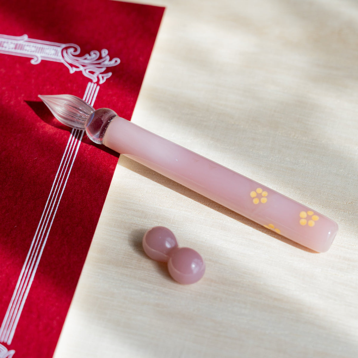 Blush Pink Flowers glass dip pen with yellow blossom motifs on a red card, pale pink glass pen rest beside