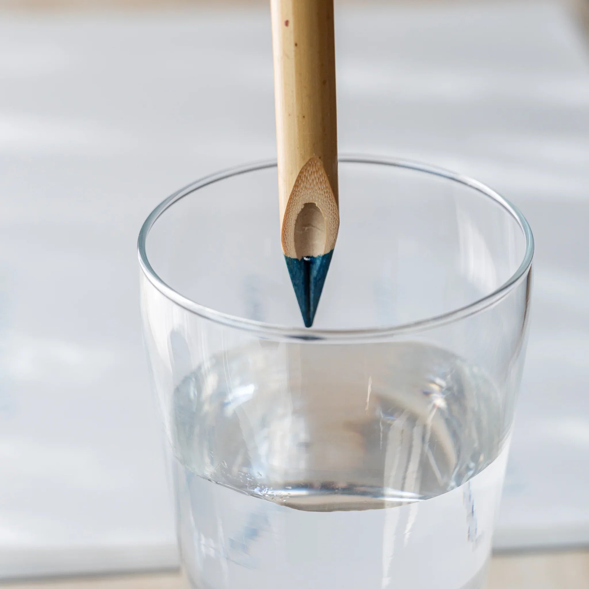 Boku-Undo bamboo dip pen standing upright in a clear glass of water, nib submerged for cleaning