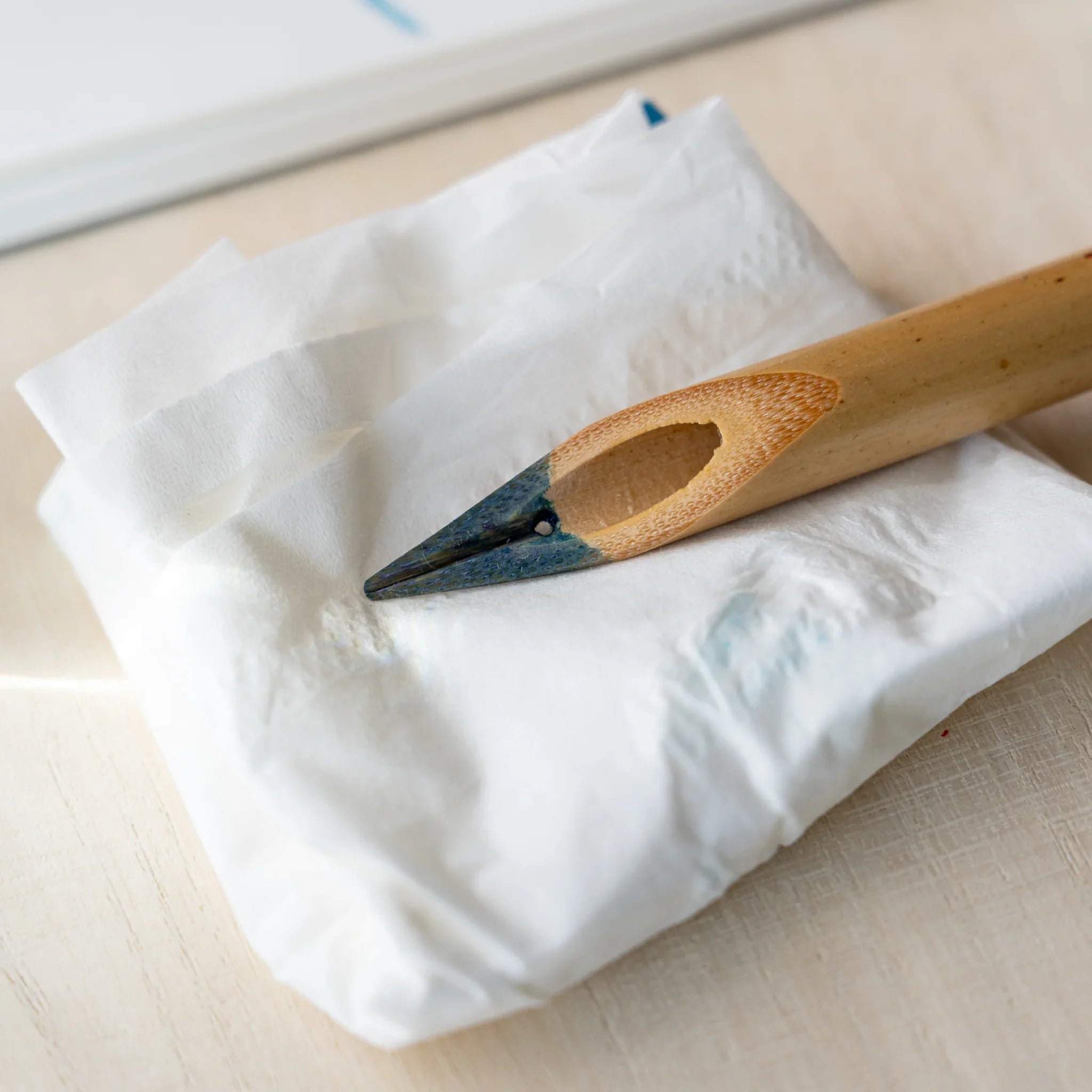 Boku-Undo bamboo dip pen resting on crumpled white tissue after cleaning, nib showing residual blue ink