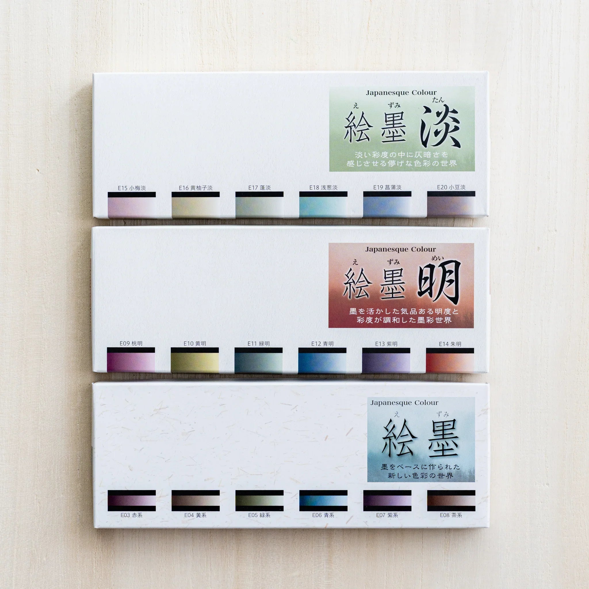 Three closed Boku-Undo Sumi Ink Watercolor boxes stacked, showing the Pastel, Bright, and Shadow Black variants