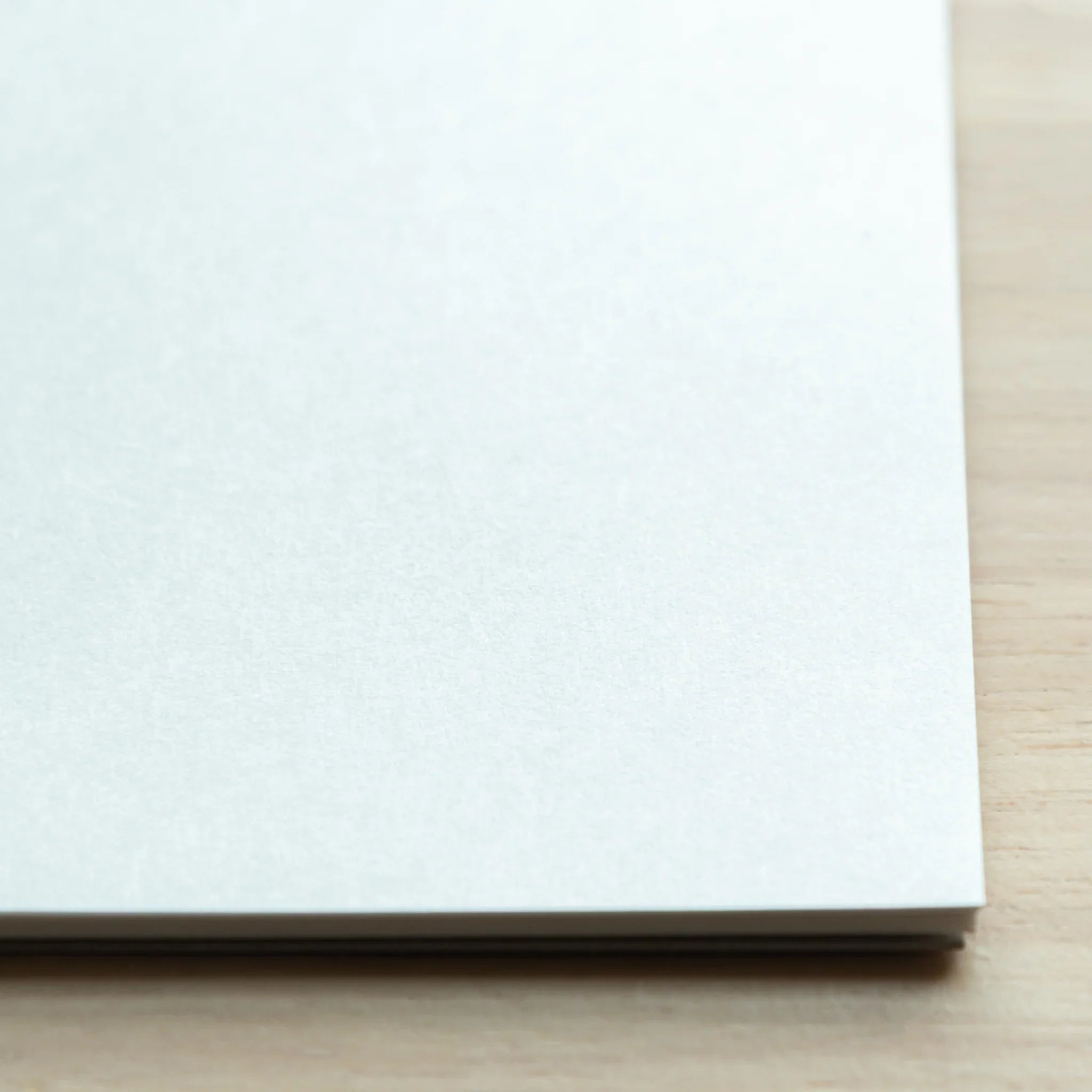 Close-up corner of Bullet Jotter writing pad, light blue-tinted Sheep Clouds Bond paper texture and stacked sheet edges