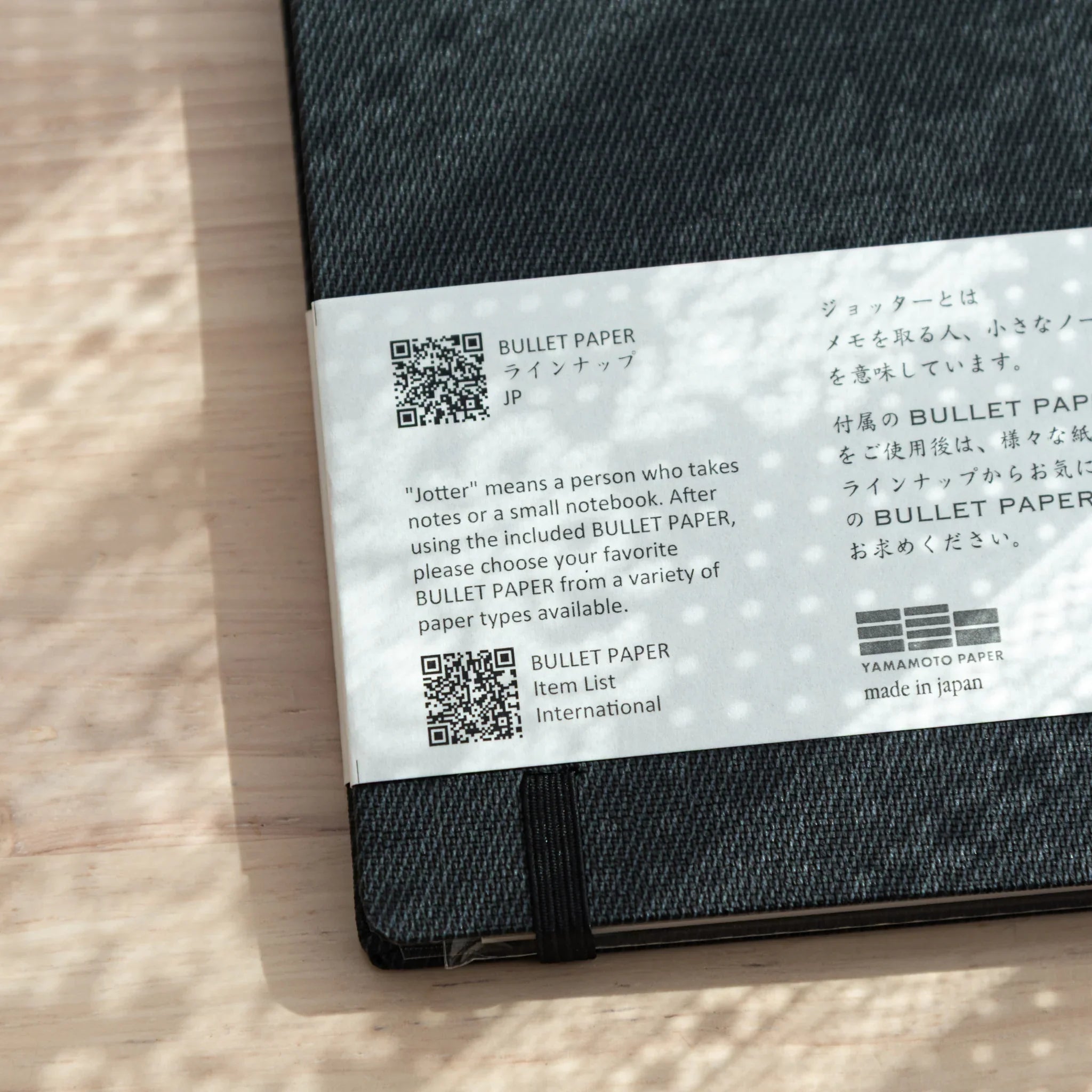 Bullet Jotter black gabardine cover back view: belly band with QR codes, bilingual product description, Yamamoto Paper logo