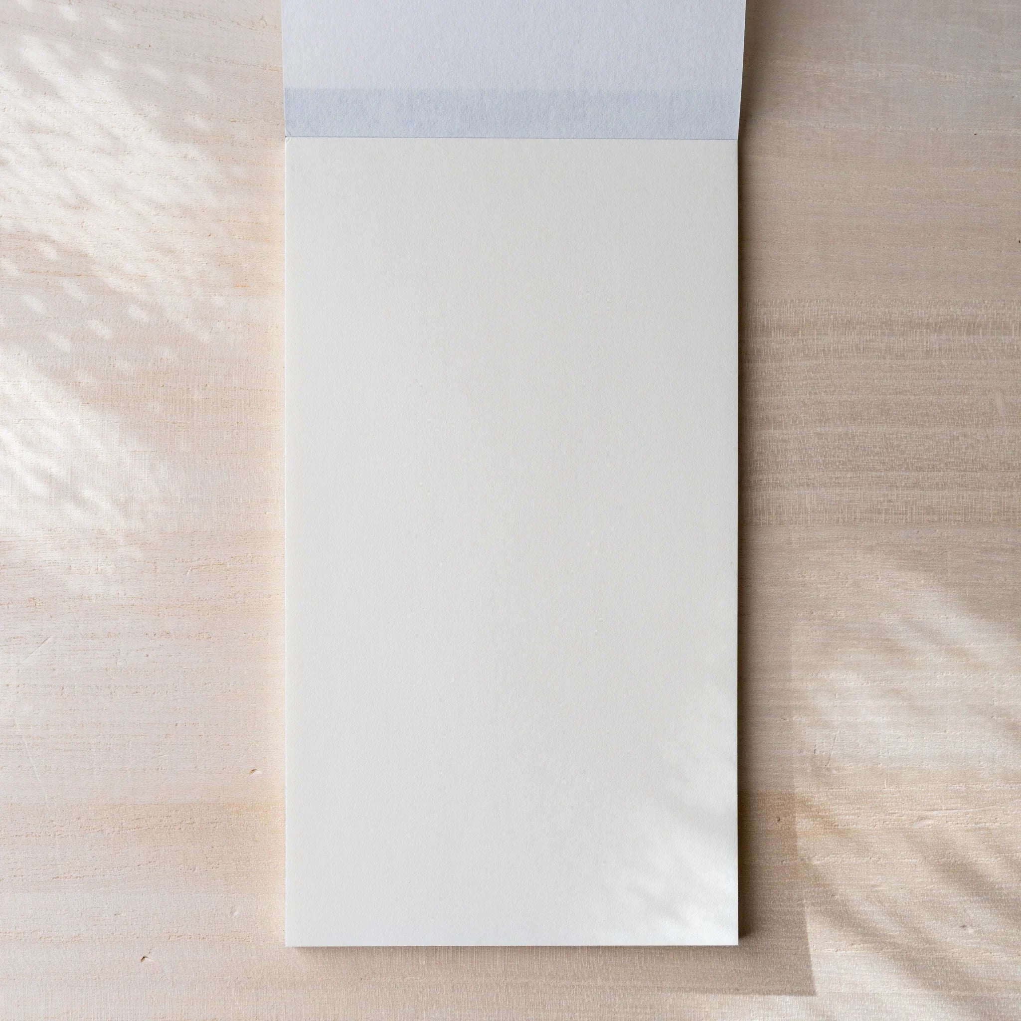 Yamamoto Paper Soliste Bullet Paper No.4 notepad opened to first cream-tinted blank sheet with cloth binding.