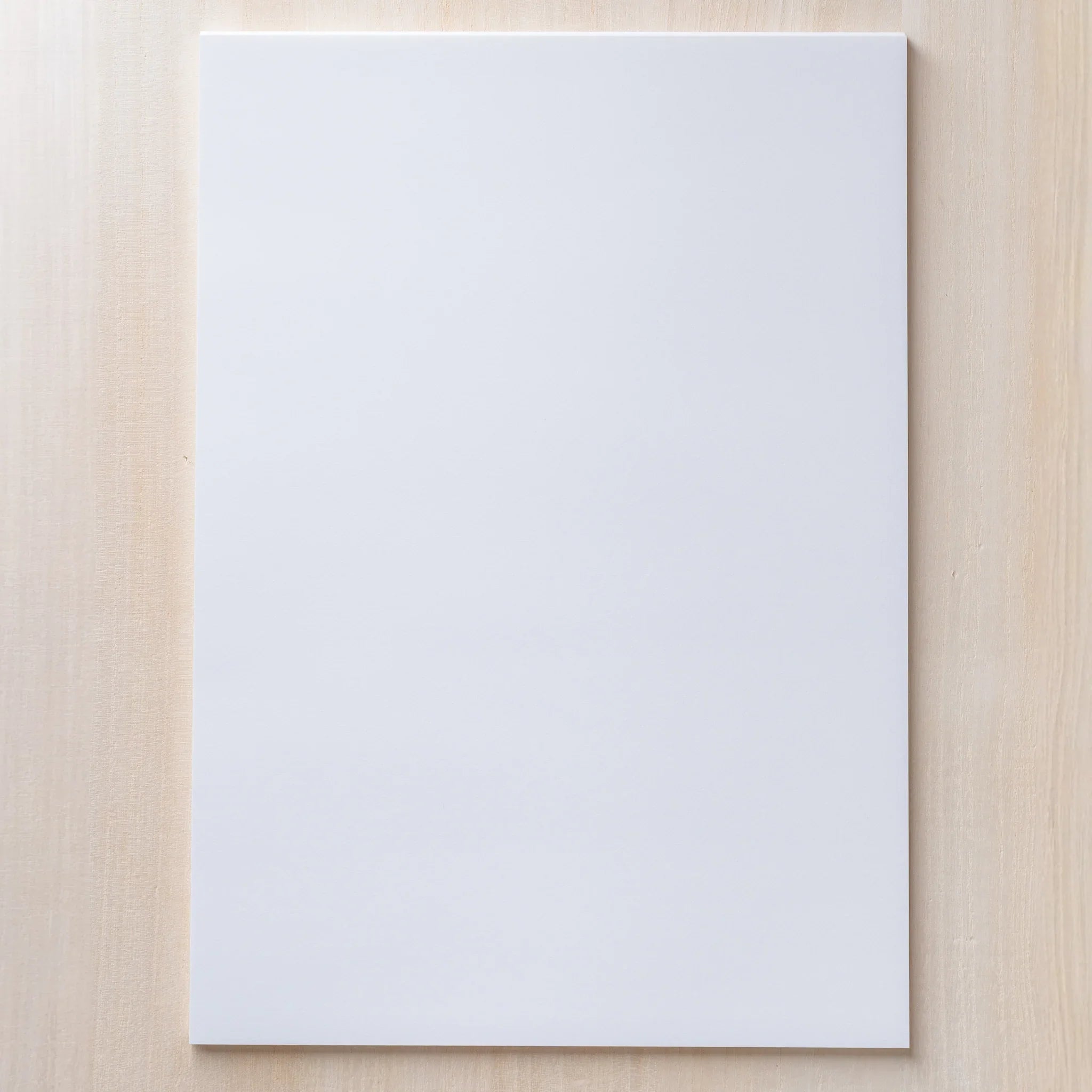 Single A4 sheet of Yamamoto Paper Canopus loose leaf paper laid flat on a wood surface.