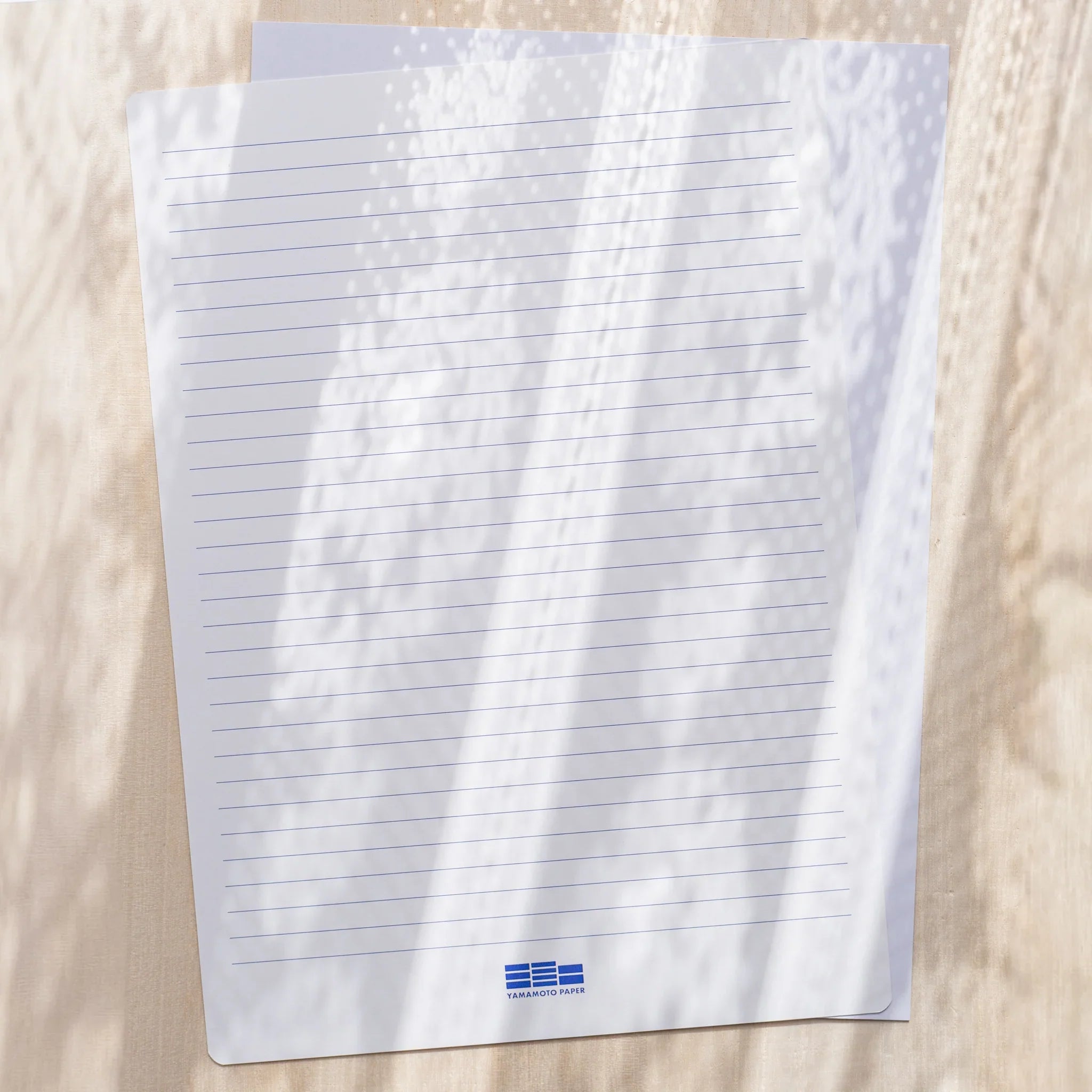 Yamamoto Paper Canopus A4 loose leaf sheet shown with printed horizontal line template overlay.