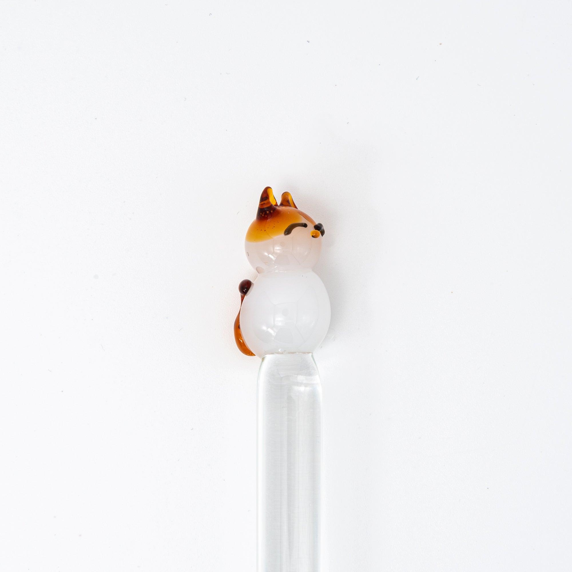 Glass pen with a cat topper and clear shaft, featuring a cute and playful design. Perfect for adding charm to your writing.