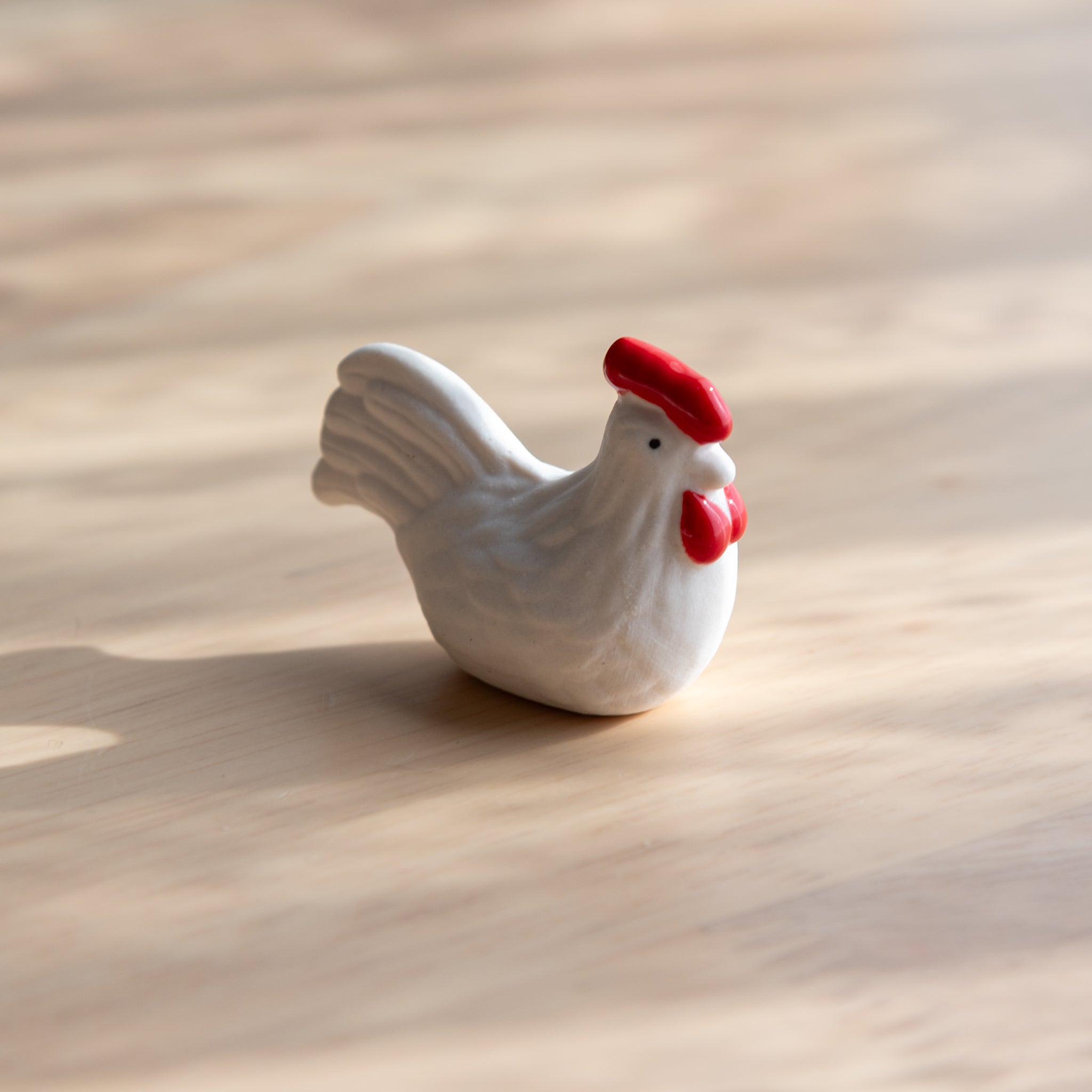 A handmade ceramic pen rest shaped as a white chicken, showcasing Japanese stationery craftsmanship with a whimsical design.