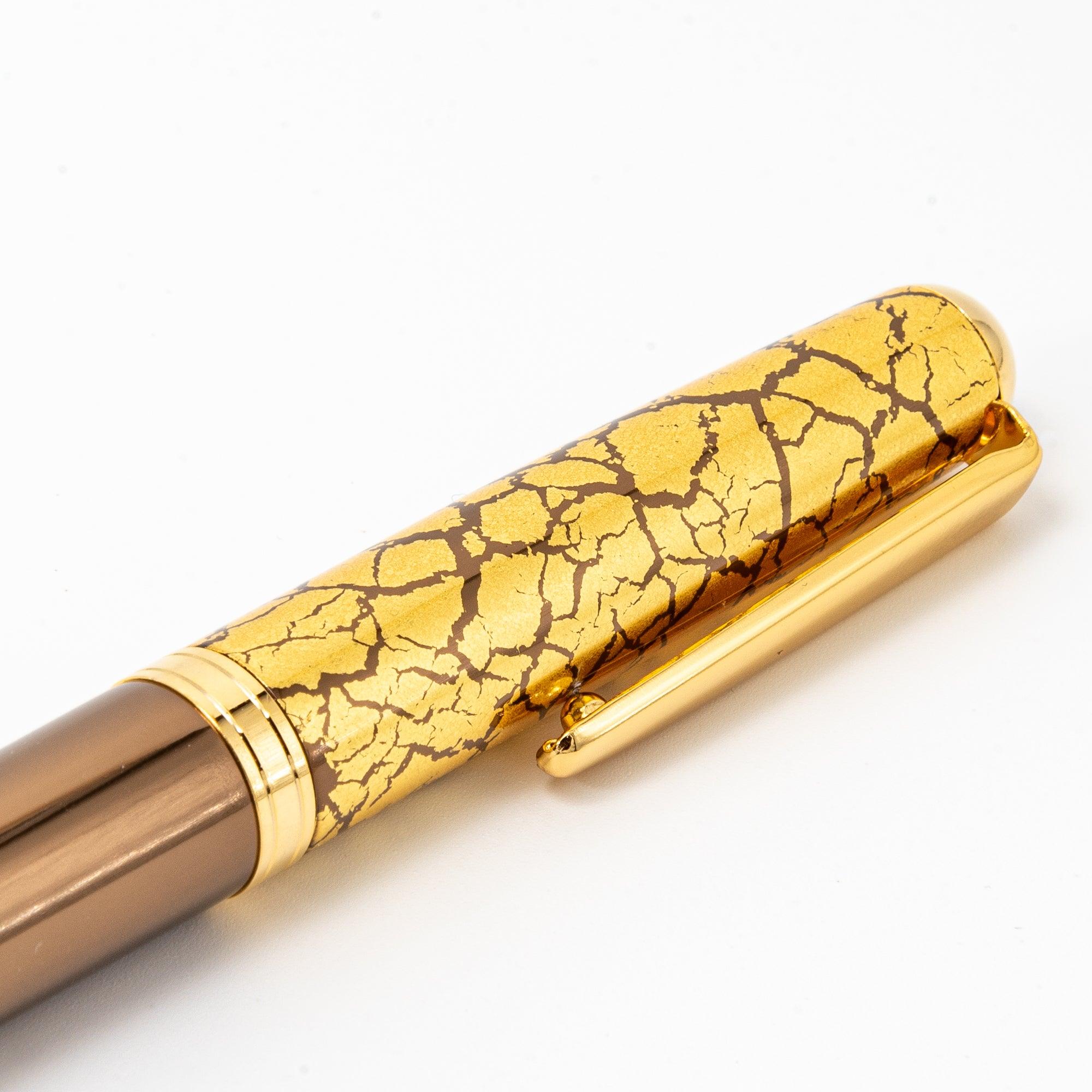 Detailed view of the pen barrel showing the crackled gold-leaf pattern against the rich brown lacquered surface.