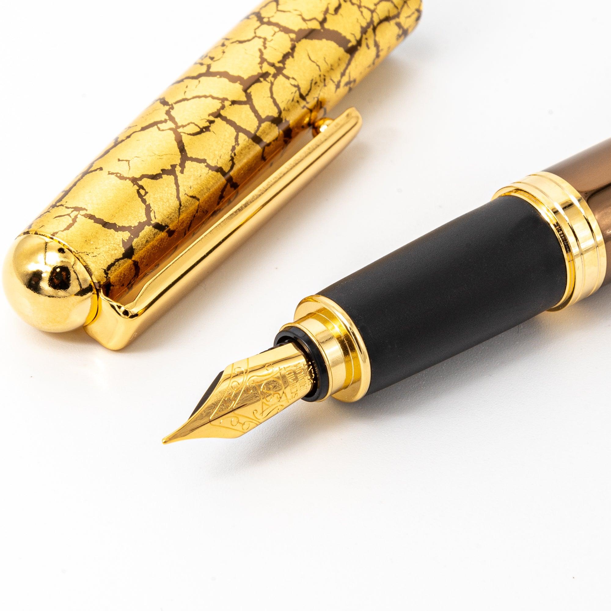 Brown fountain pen displayed diagonally on a reflective surface, emphasizing its crackled gold-leaf design and luxurious finish.