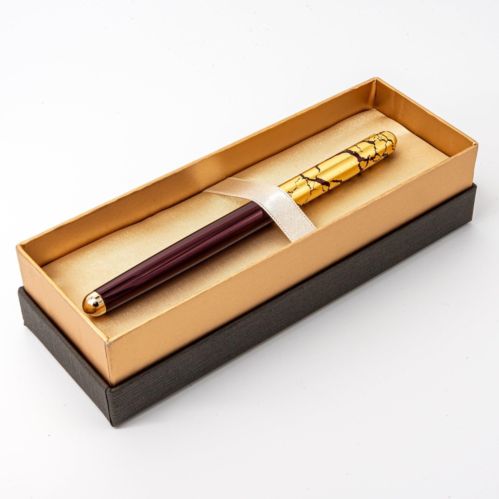 A wine-red ballpoint pen with a gold crack pattern cap, elegantly presented in a satin-lined box, ideal for gifting occasions.