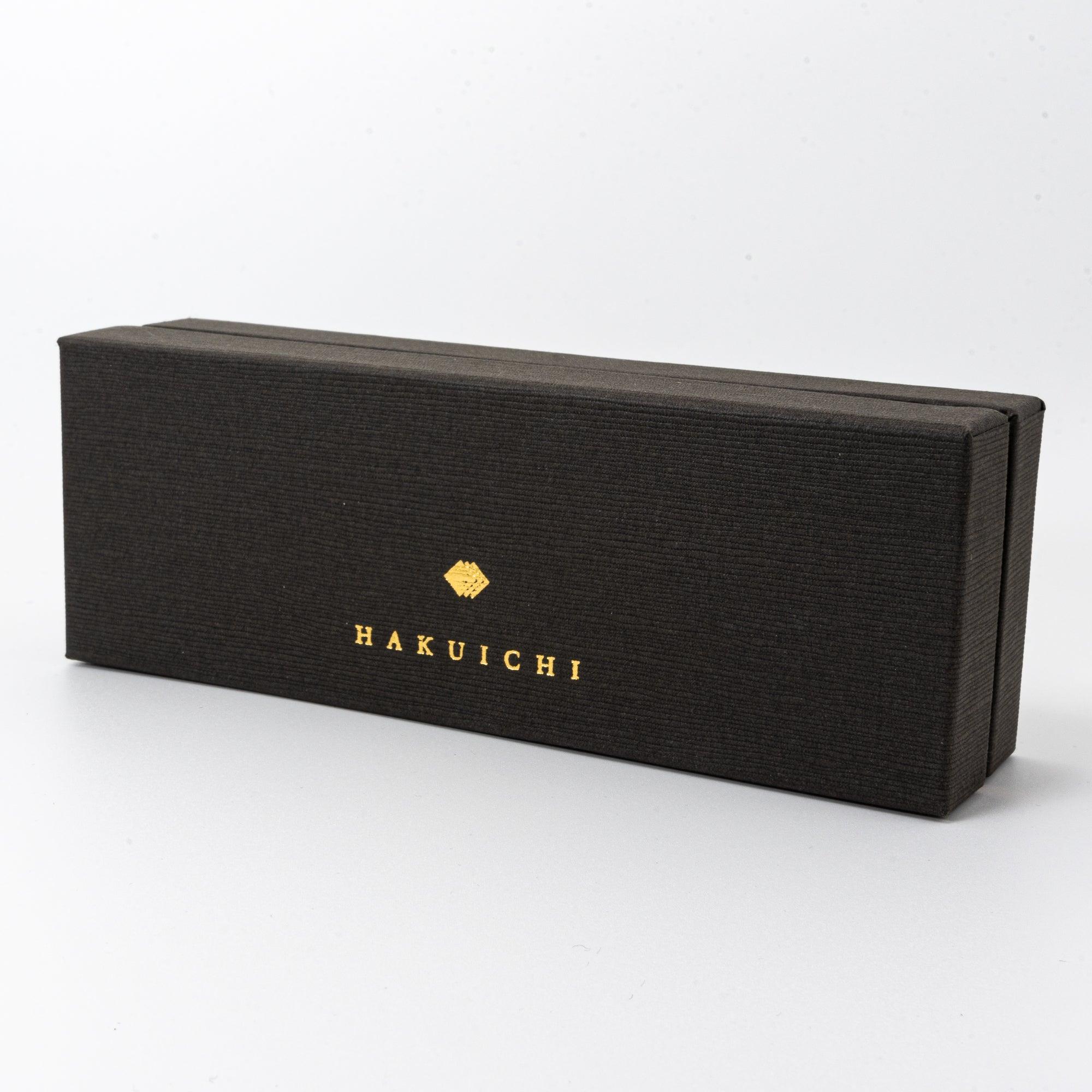 A side view of the Hakuichi black box, featuring textured material and gold lettering, reflecting refined craftsmanship.