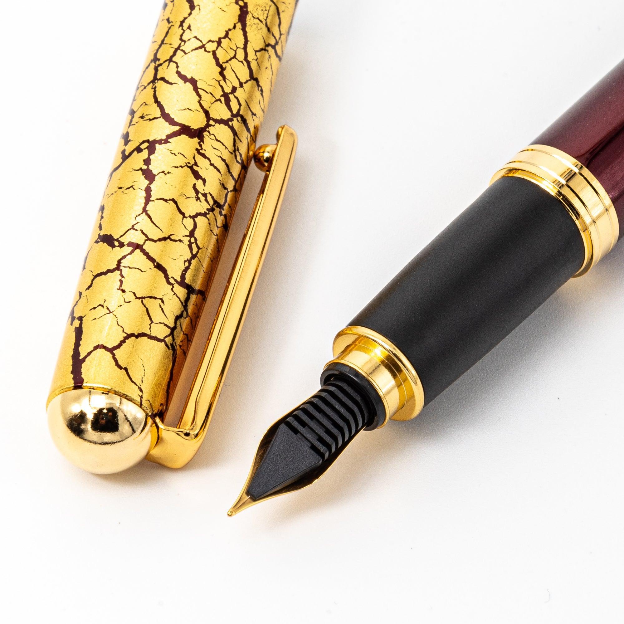 Japanese fountain pen showcasing its crackled gold-leaf cap, smooth black grip section, and polished wine-red lacquered barrel.