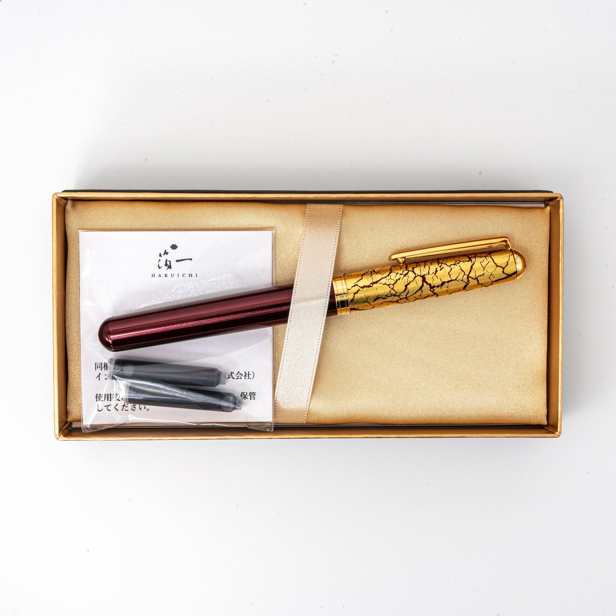 Wine-red Japanese fountain pen presented in a gold-lined gift box, complete with additional ink cartridges for a luxurious experience.