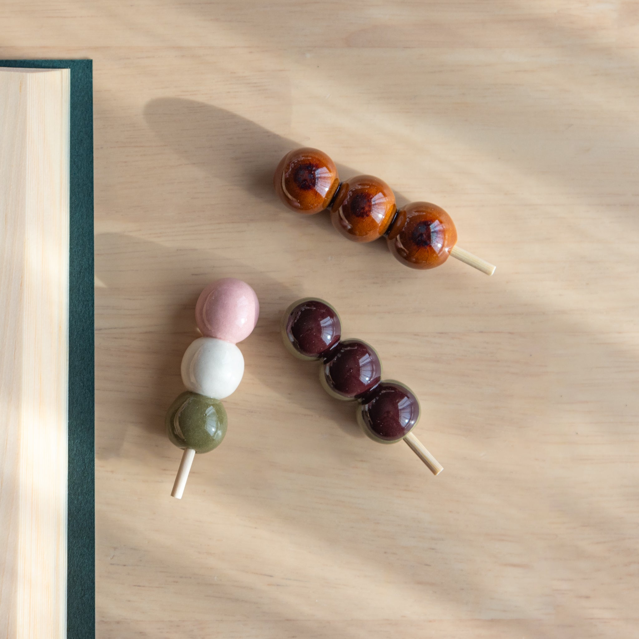 Handmade ceramic pen rests shaped as Japanese dango skewers, showcasing vibrant designs and traditional Japanese stationery craftsmanship.