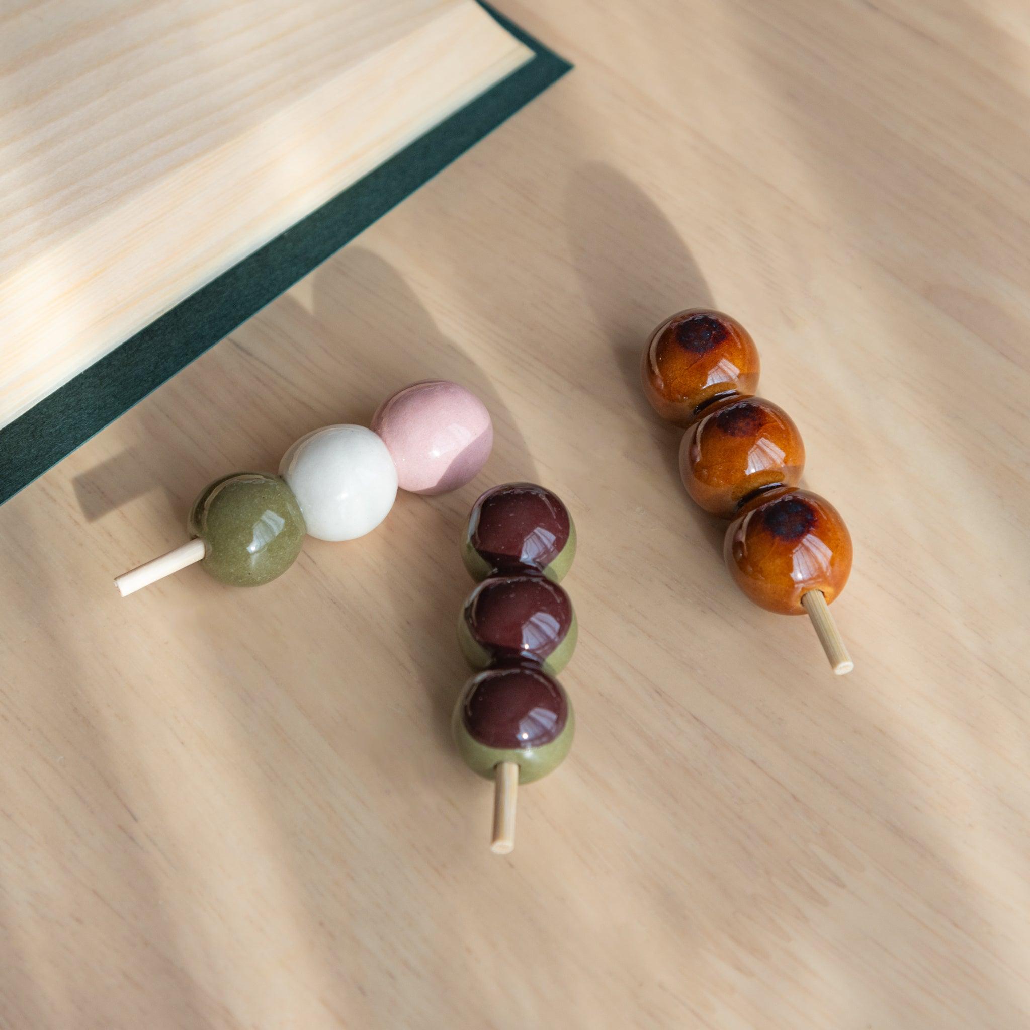 Handmade ceramic pen rests shaped as Japanese dango skewers, showcasing vibrant designs and traditional Japanese stationery craftsmanship.