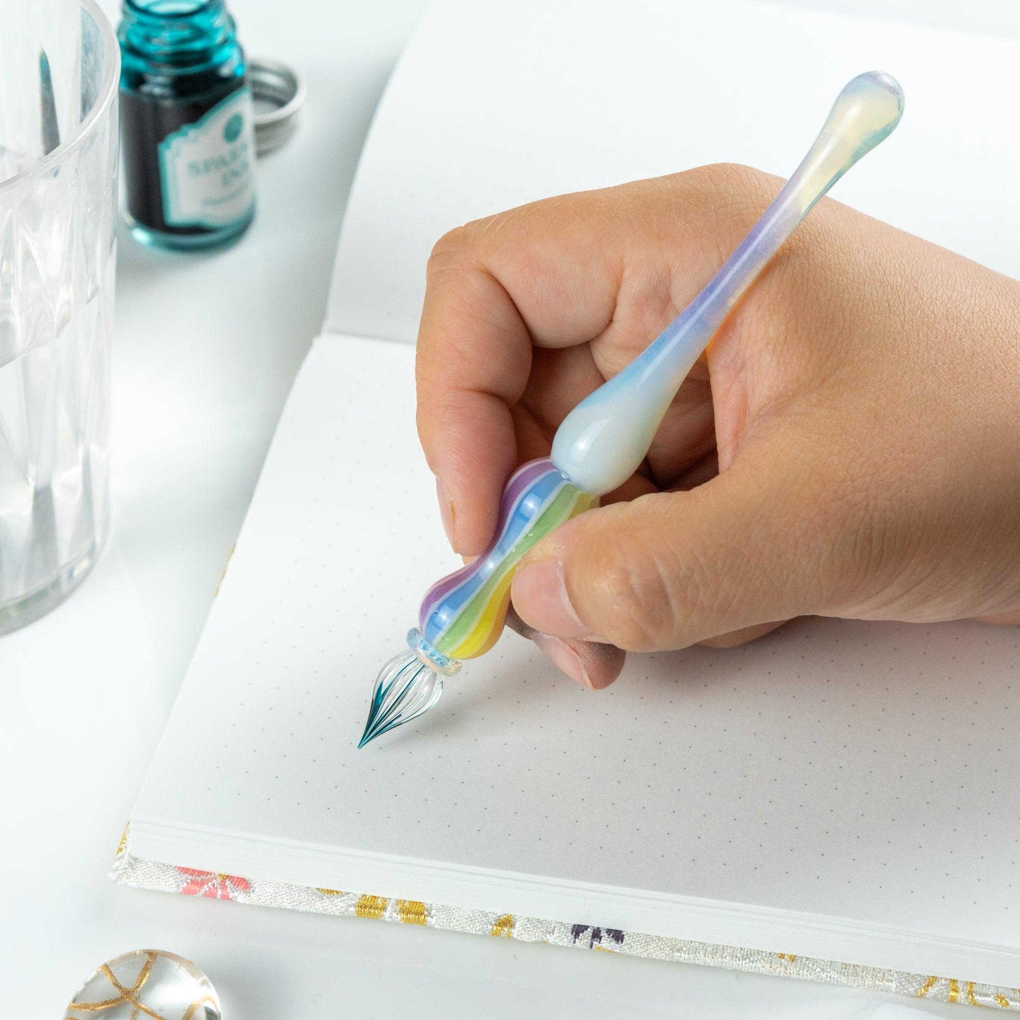 Hand writing with a glass pen featuring a rainbow-colored handle. Ideal for fans of Japanese stationery.