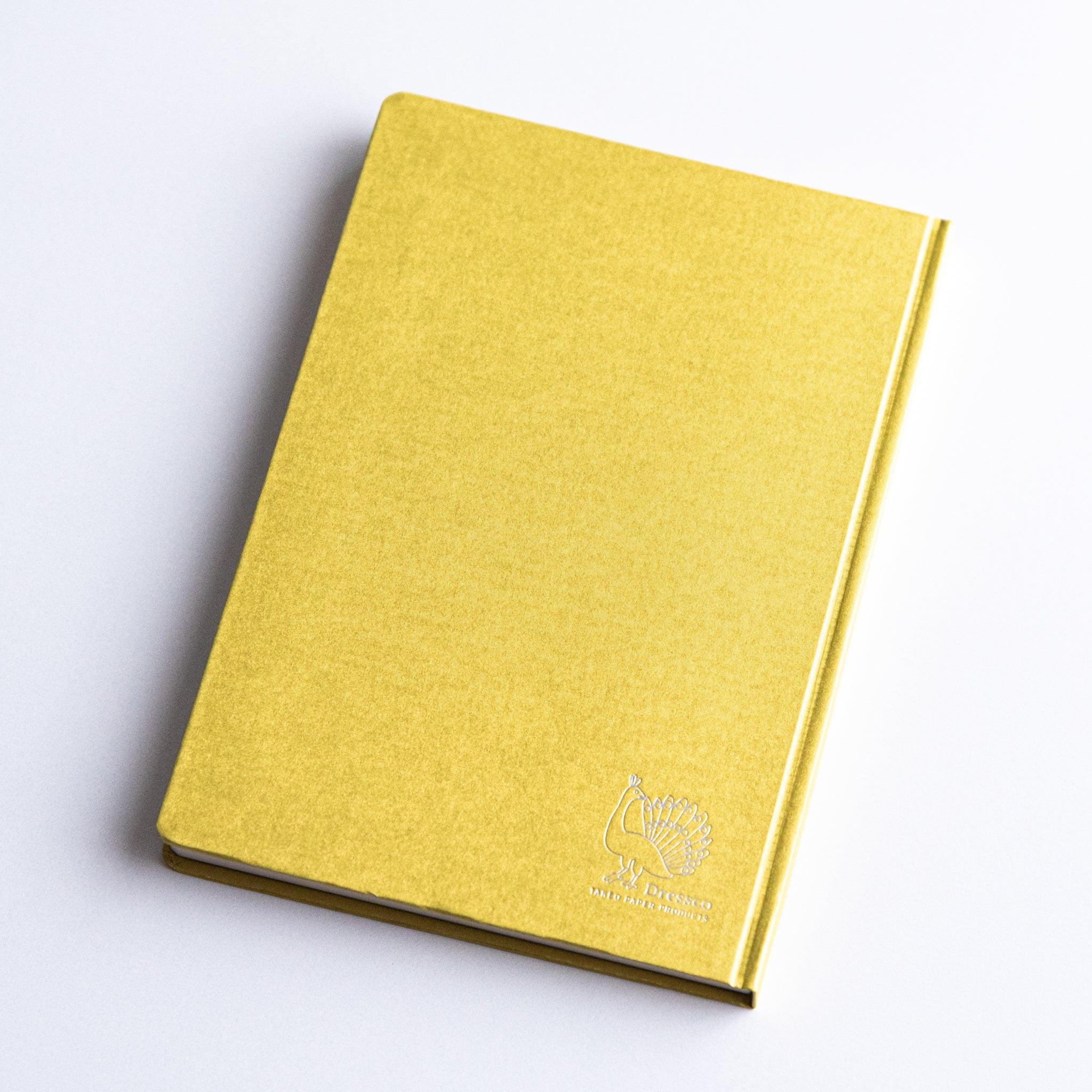 Angled view of Dressco Bank Ledger Paper Japanese Notebook in Gold with embossed logo.