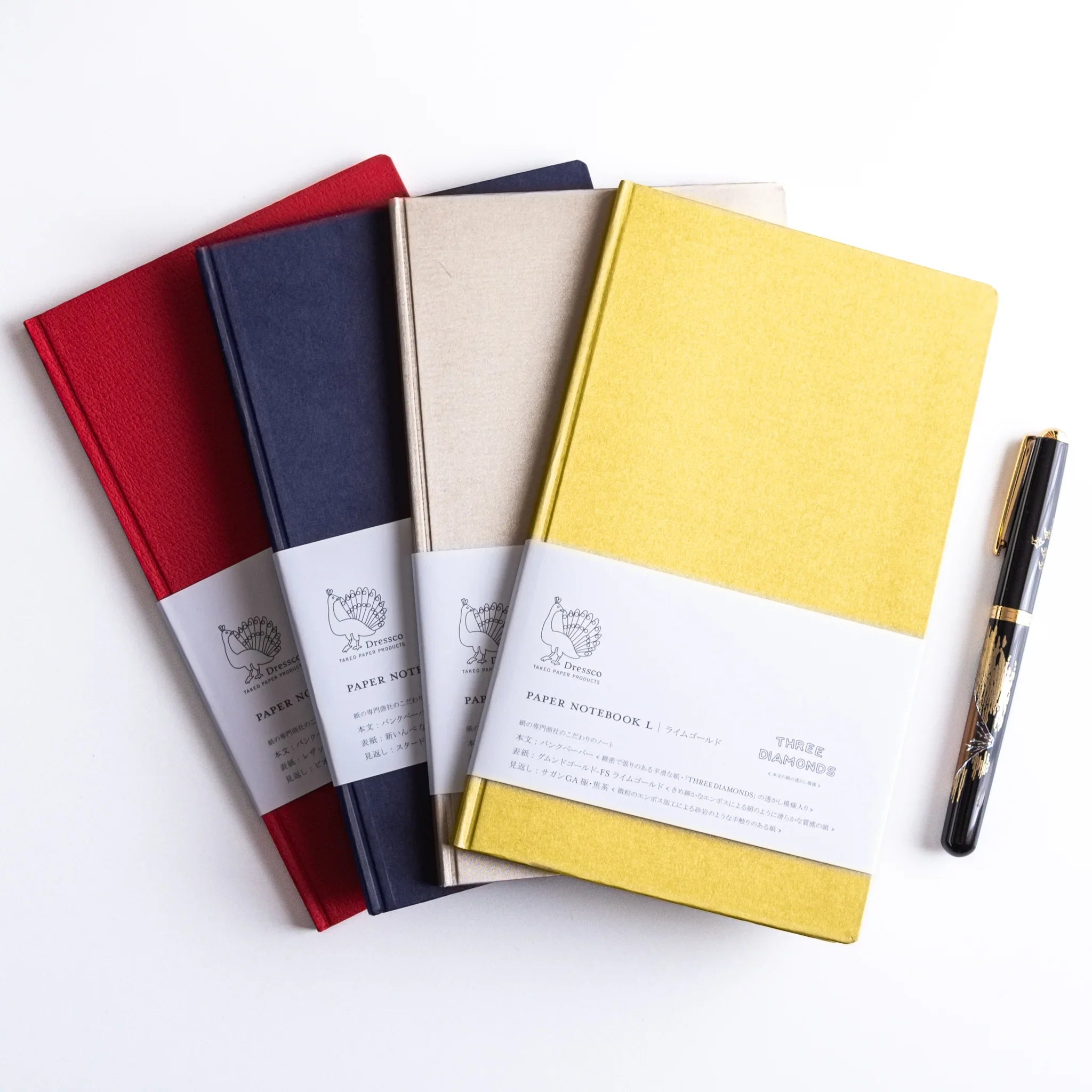 Four Dressco Bank Ledger Paper Japanese Notebooks in red, navy, beige, and gold with Japanese Fountain Pen.