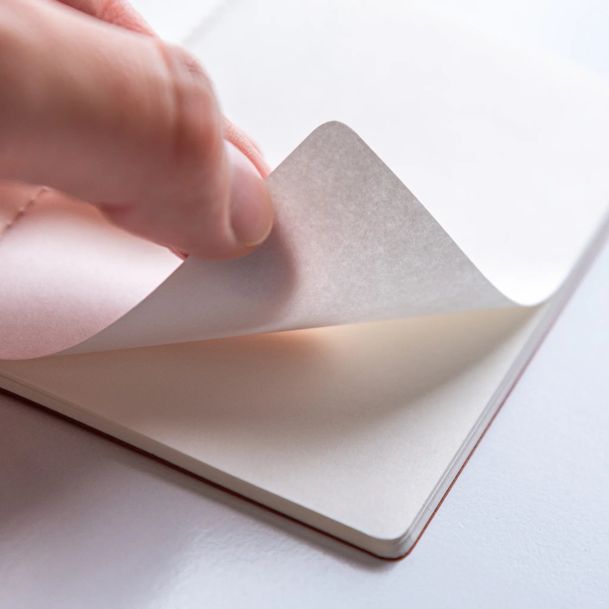 Turning pages of Dressco Bank Ledger Paper Stitched Japanese Notebook, Gray, showing paper texture.