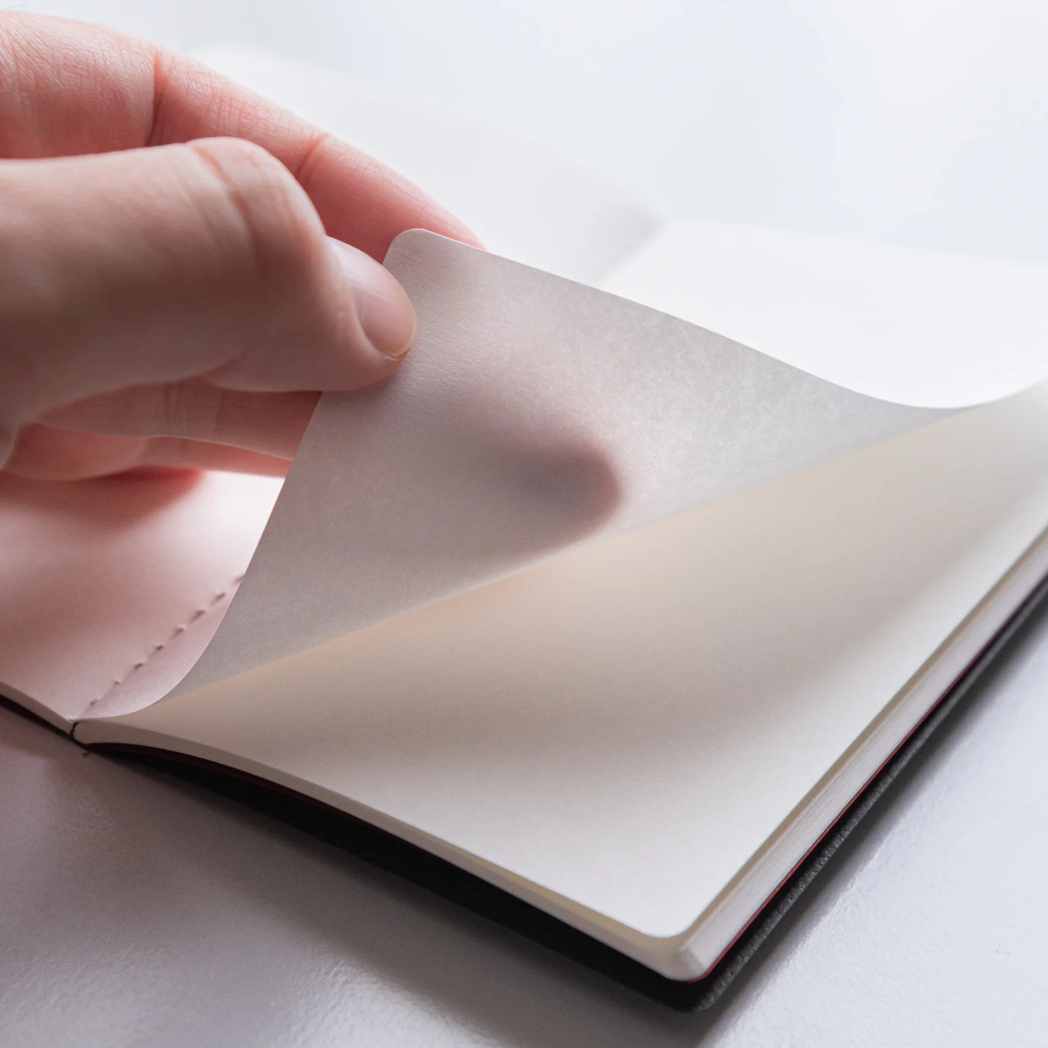 Turning pages of Dressco Bank Ledger Paper Stitched Japanese Notebook, Gray, showing paper texture.