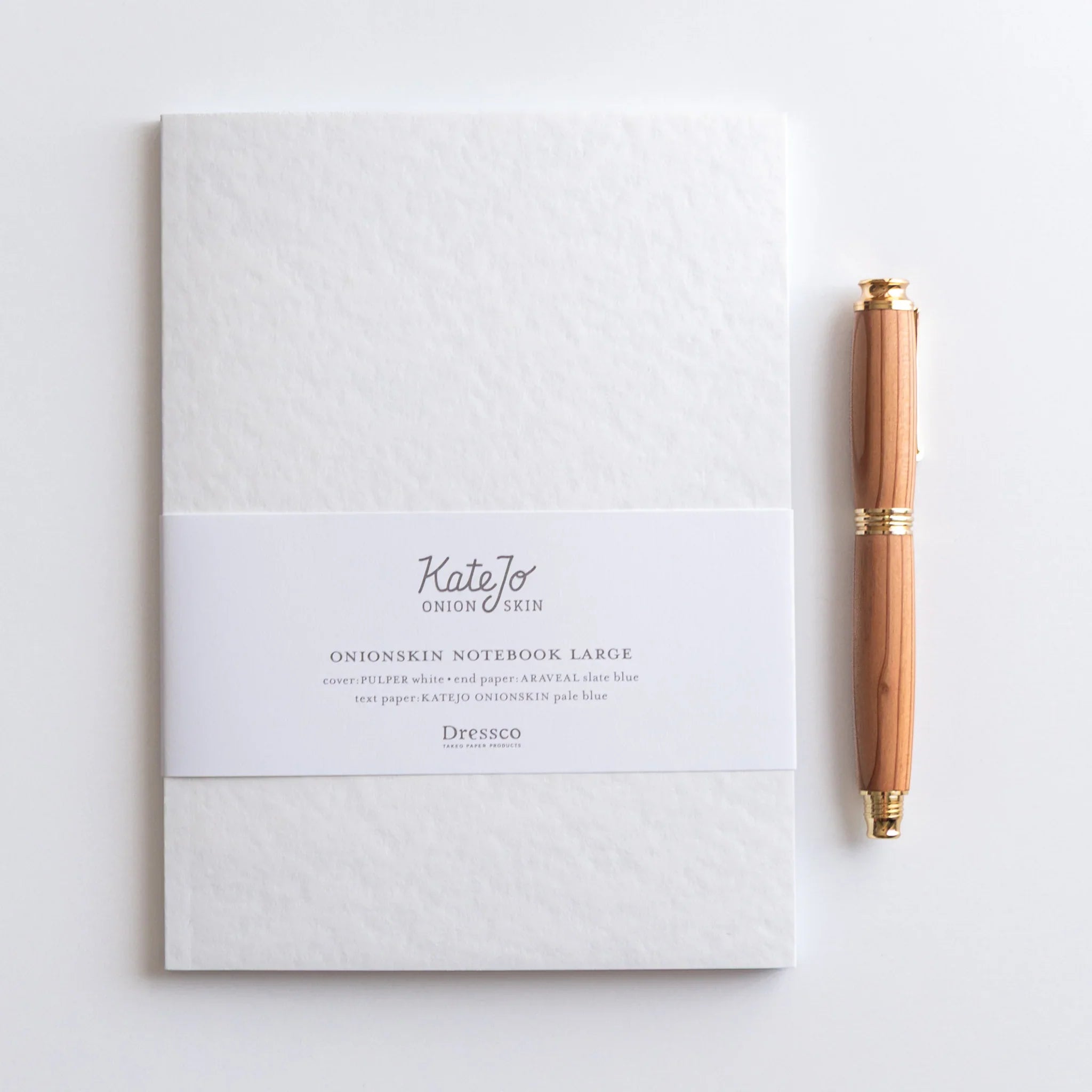 Dressco Blue Onion Skin Japanese Notebook B6 with wooden fountain pen placed beside the white textured cover.