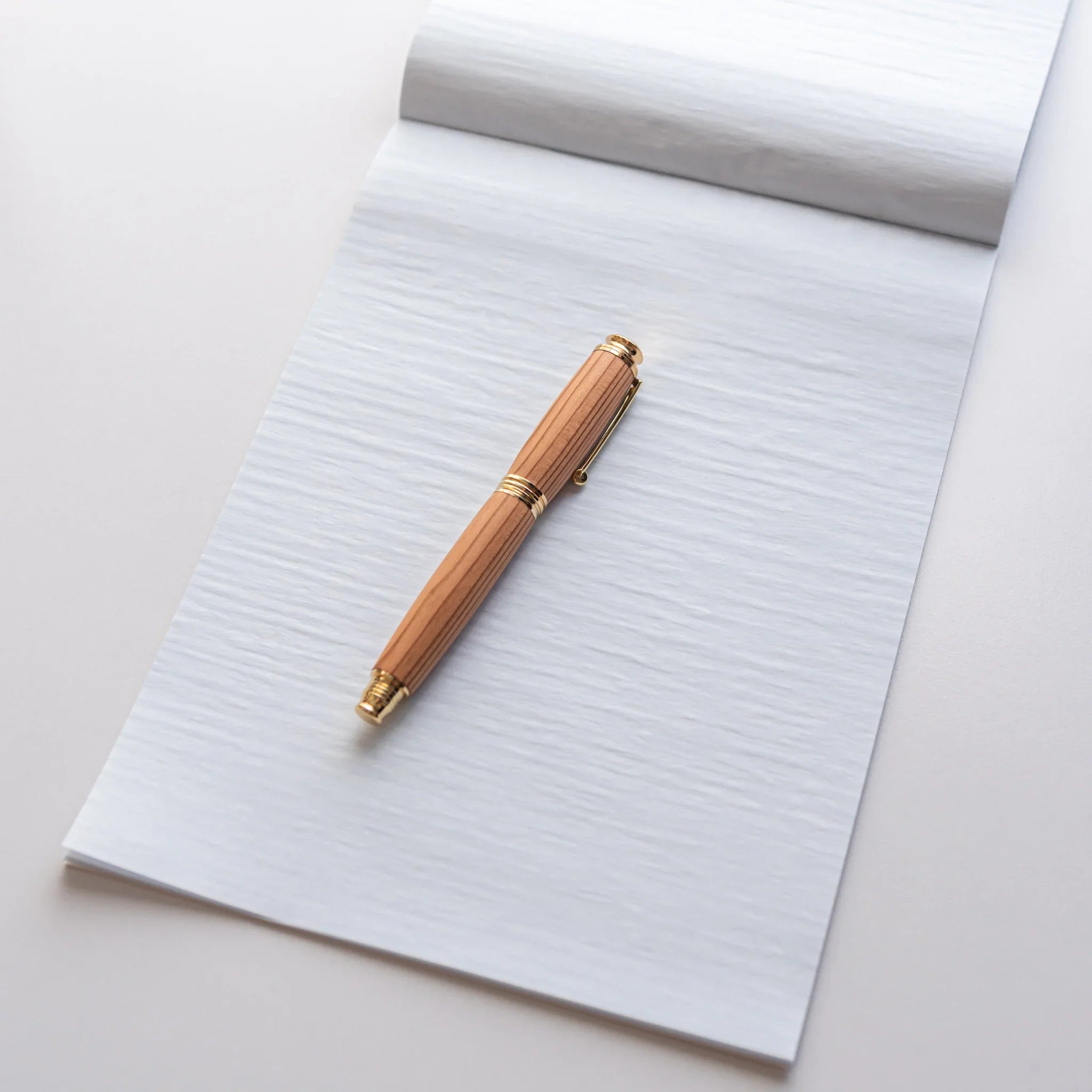 Dressco Blue Onion Skin Japanese Paper Writing Pad with wooden fountain pen placed on page.