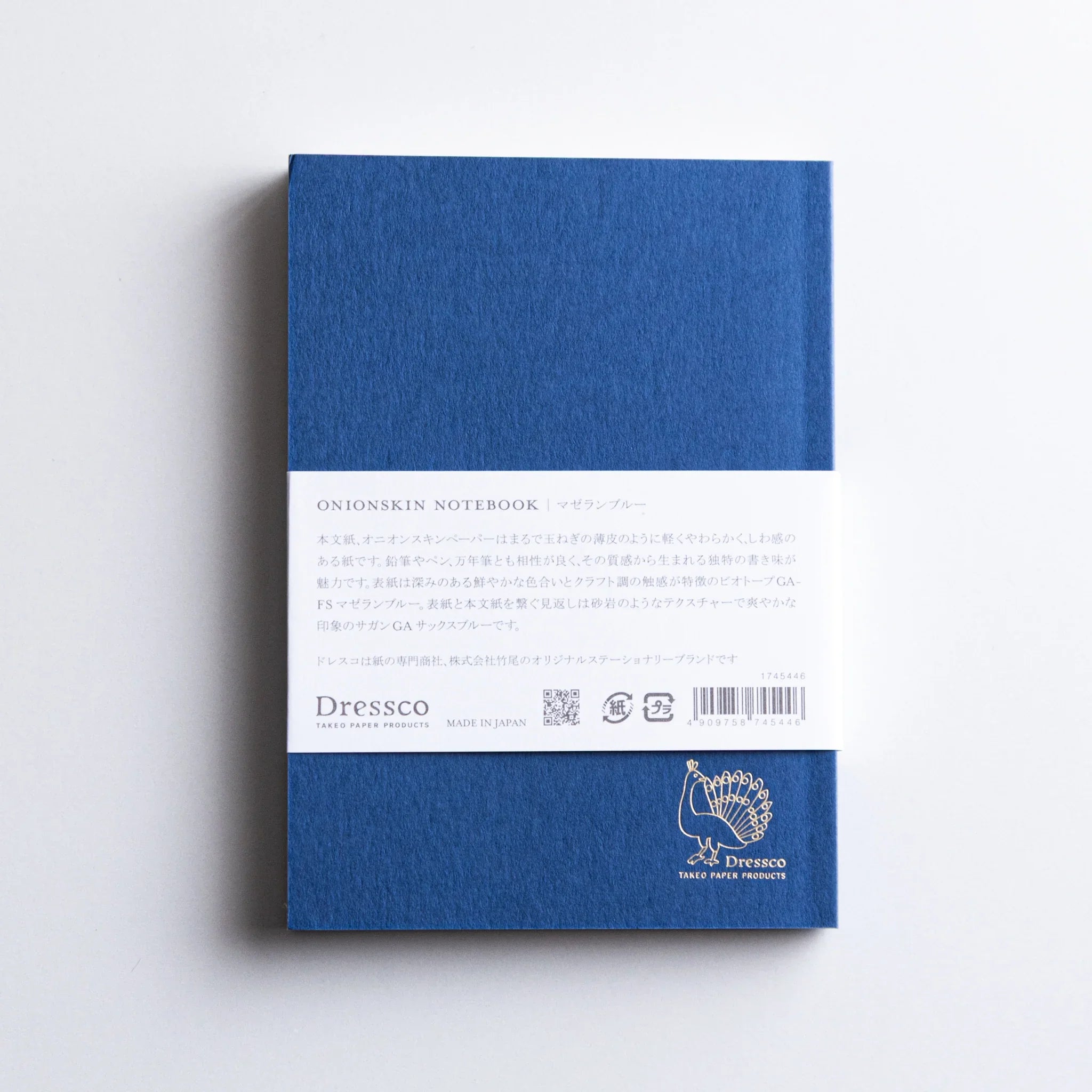 Back view of Dressco Blue Onion Skin Japanese Notebook A6 with white label and gold peacock logo.