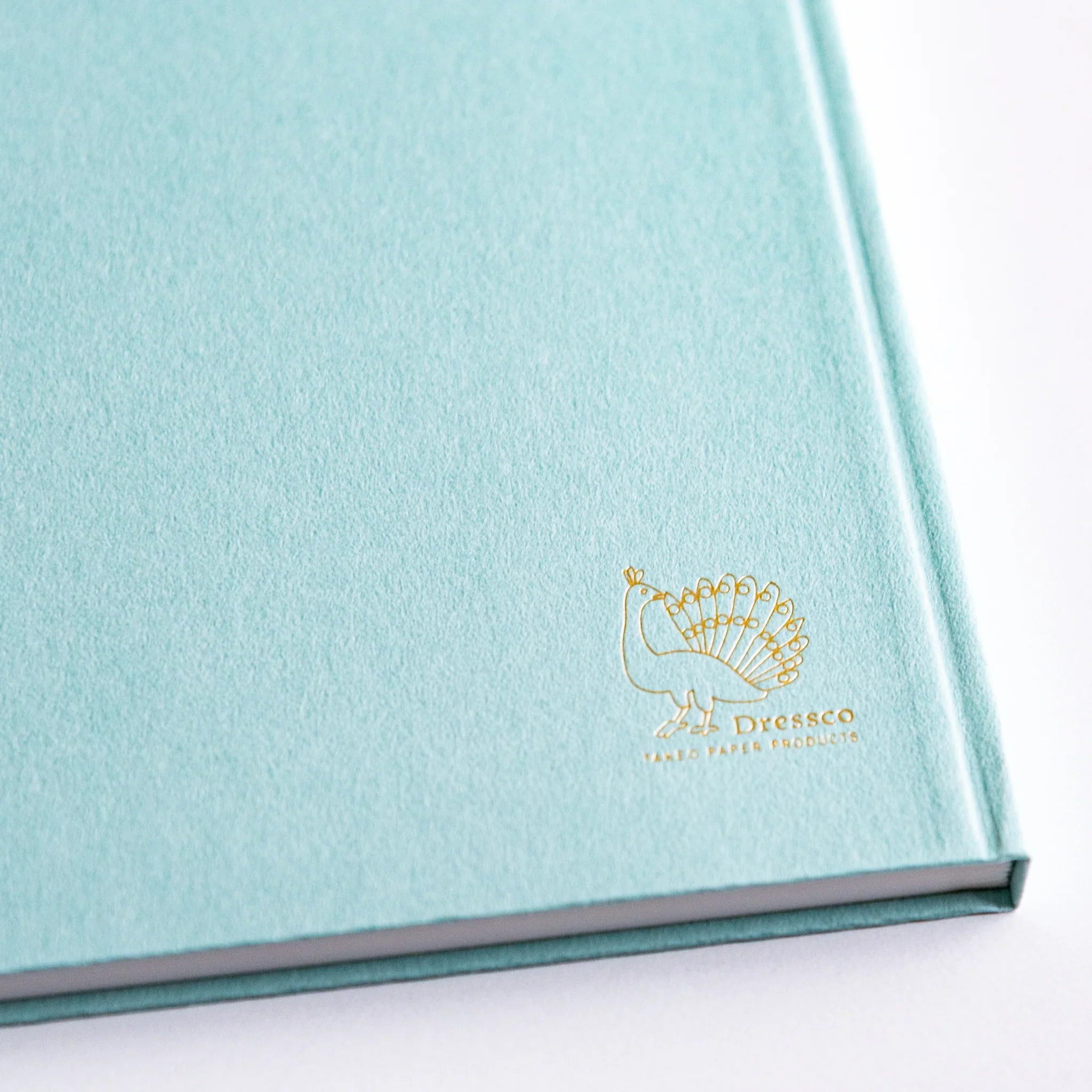 Gold Dressco peacock logo embossed on Willow Green cover of Japanese Notebook.