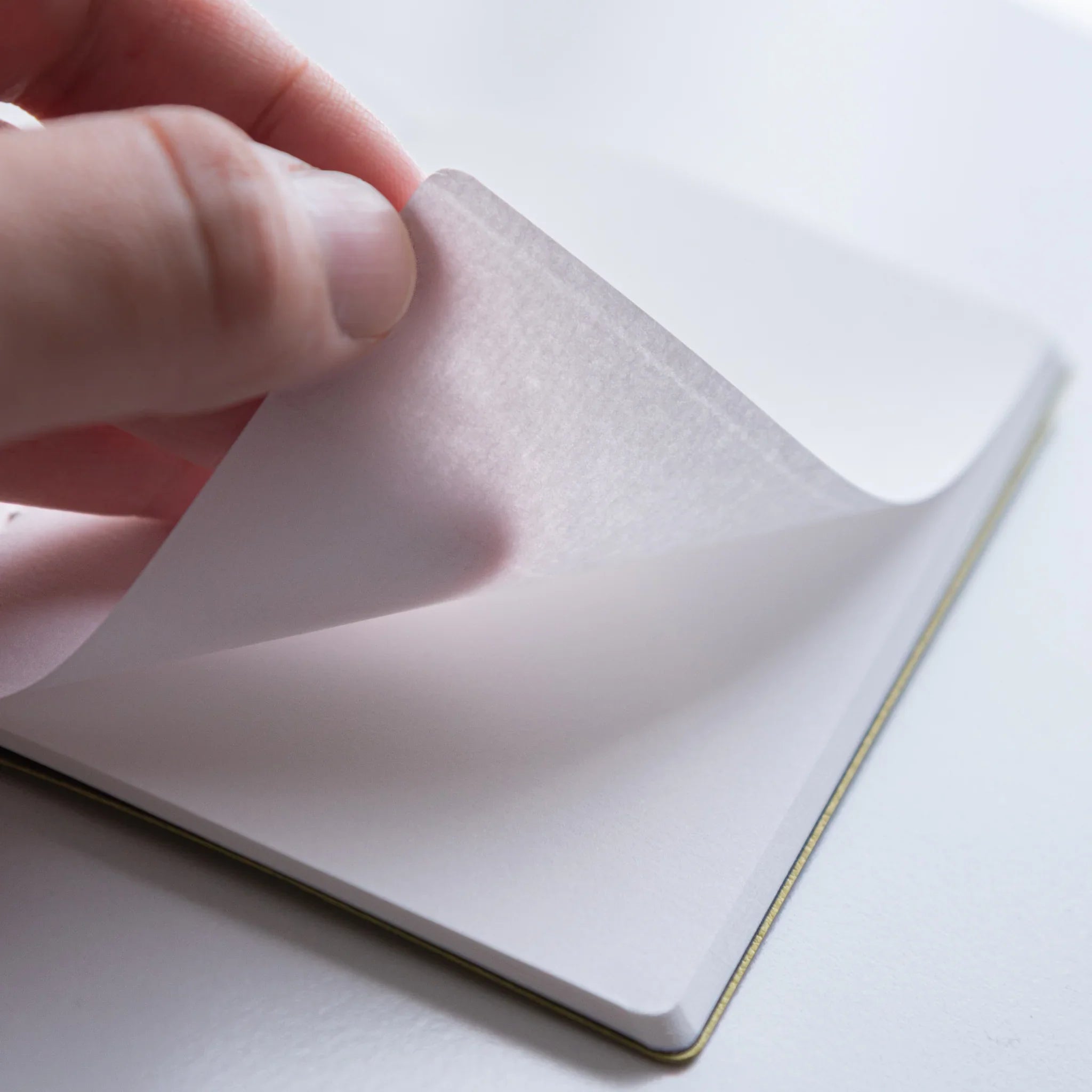 Turning a page in Dressco Spica Laid Bond Japanese Notebook, White.