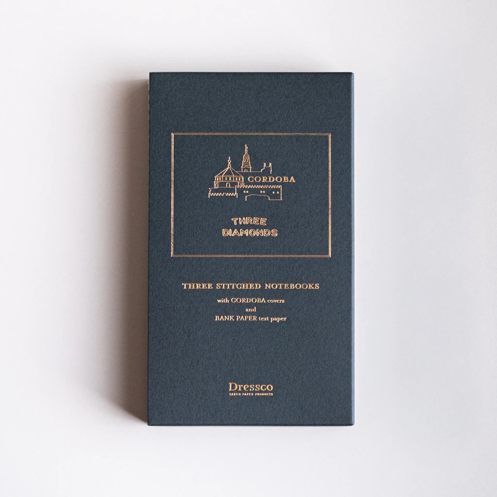 Dark blue Cordoba case with three Japanese notebooks made from Bank Ledger Paper displayed against light background.