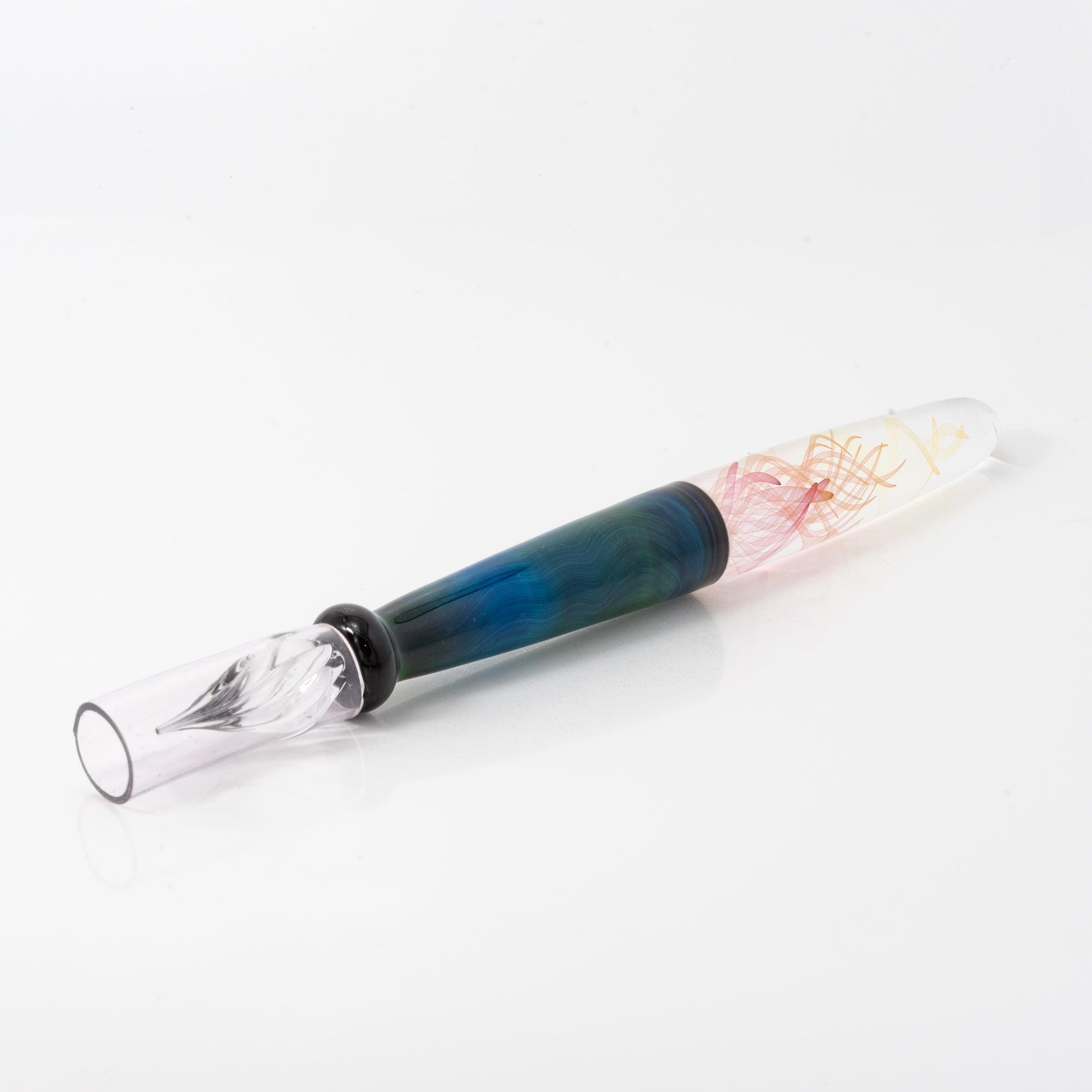 A glass pen with a blue and green body featuring swirling patterns, lying on a white background. The nib is delicately shaped for writing.