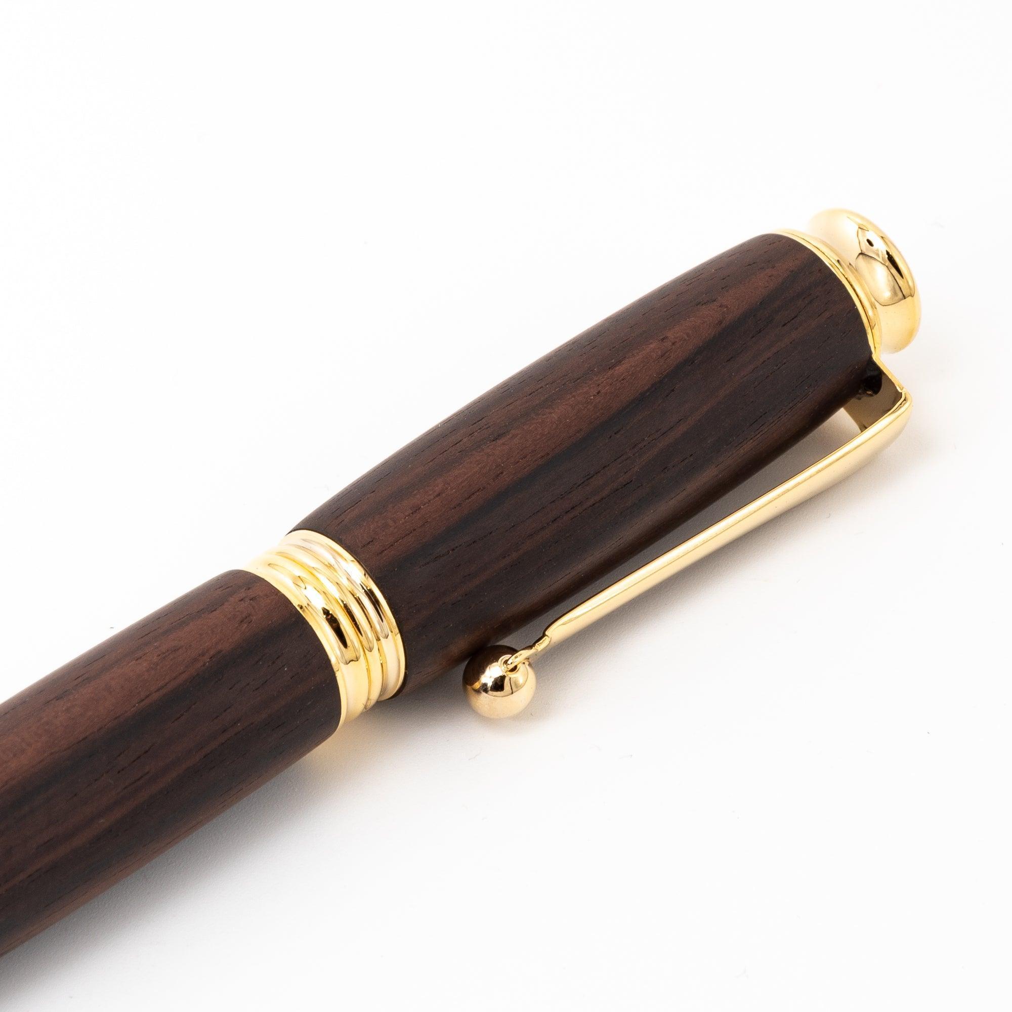 A close-up of a Japanese ebony wood fountain pen with gold accents, showcasing the clip and smooth finish on a clean white background.