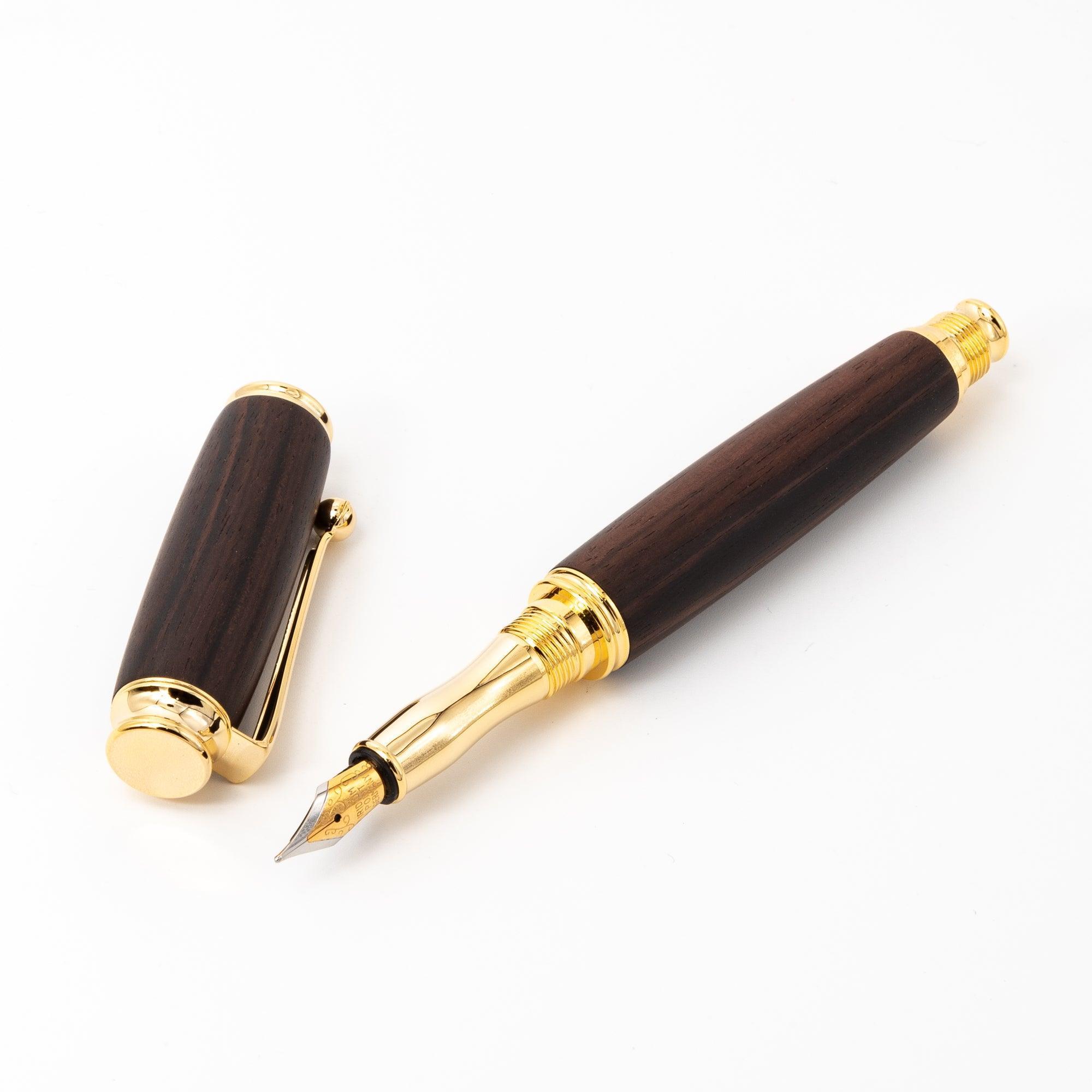 A Japanese ebony wood fountain pen with a gold nib and detachable cap, displayed open on a white surface to highlight its luxurious craftsmanship.