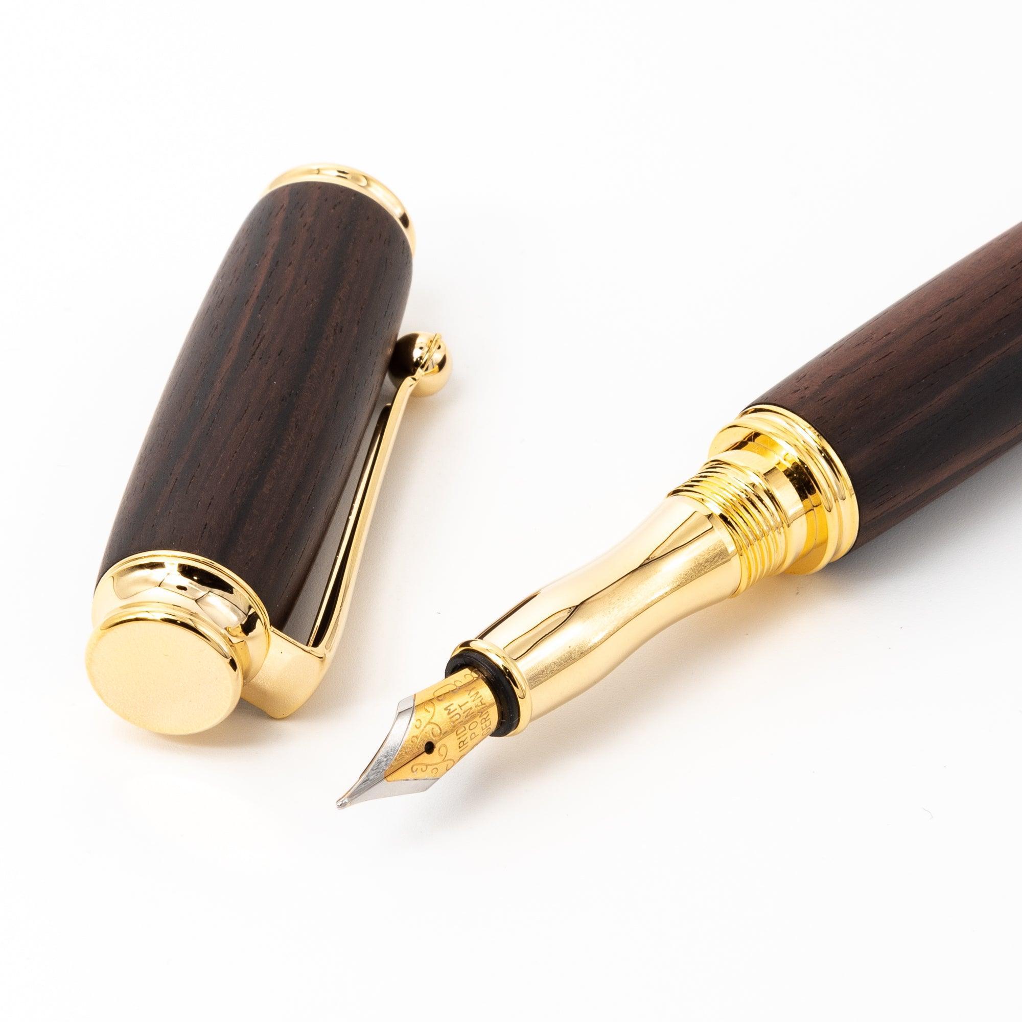 A Japanese ebony wood fountain pen with a gold nib and detached cap, highlighting its intricate details and premium craftsmanship on a white surface.