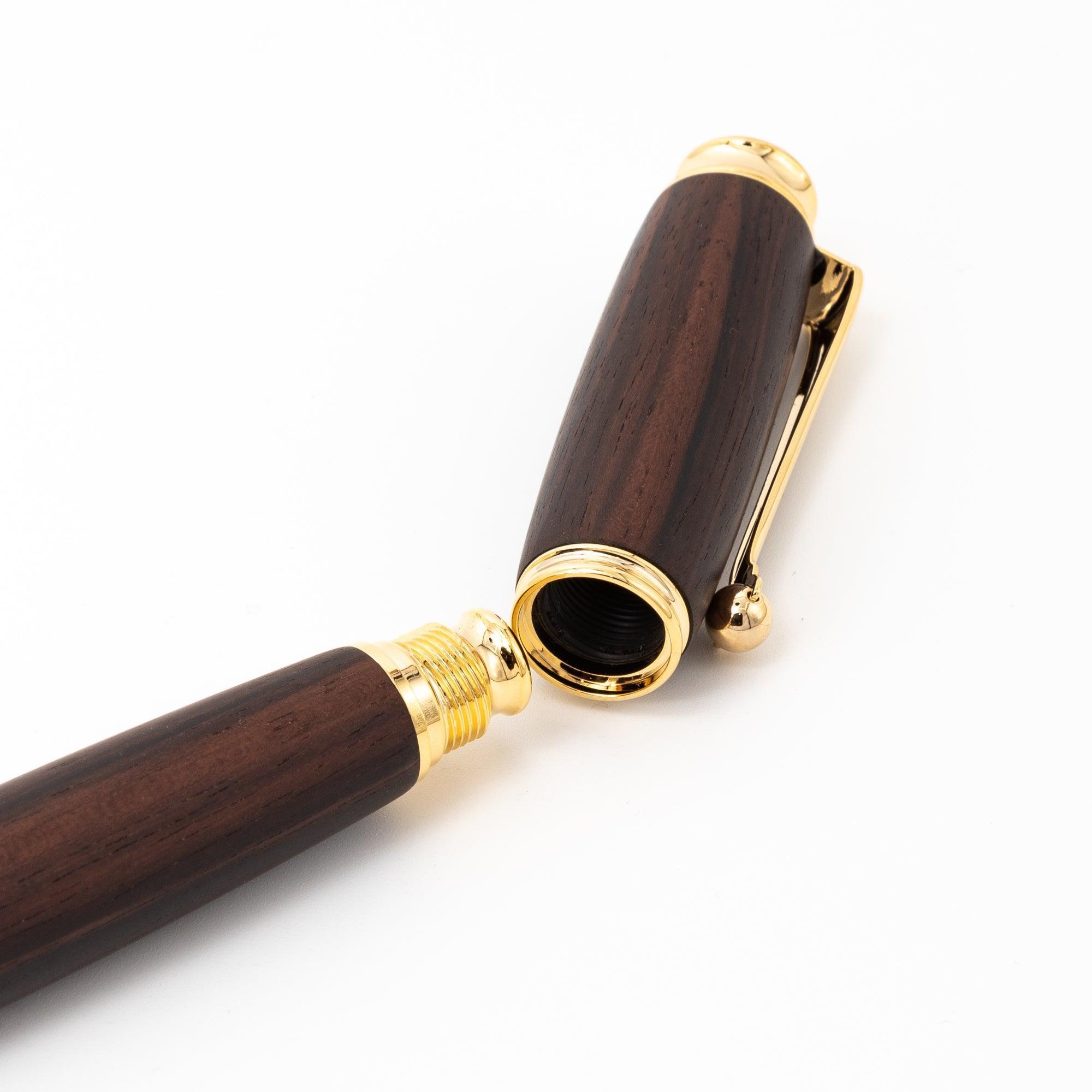 A Japanese fountain pen made of dark ebony wood, featuring a gold screw cap mechanism, displayed to emphasize its elegant design on a plain background.