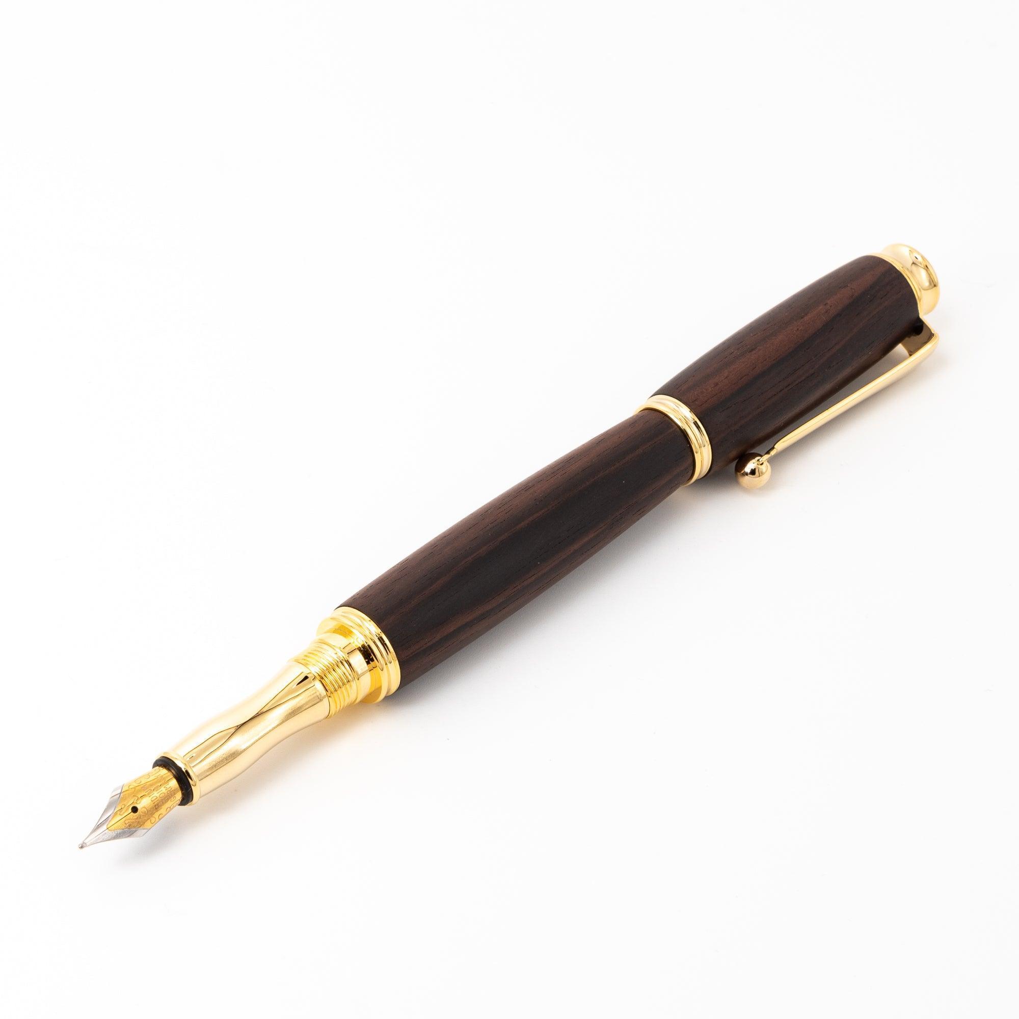 A Japanese ebony wood fountain pen with gold accents and a sleek nib, displayed open on a white surface to showcase its sophisticated aesthetic.