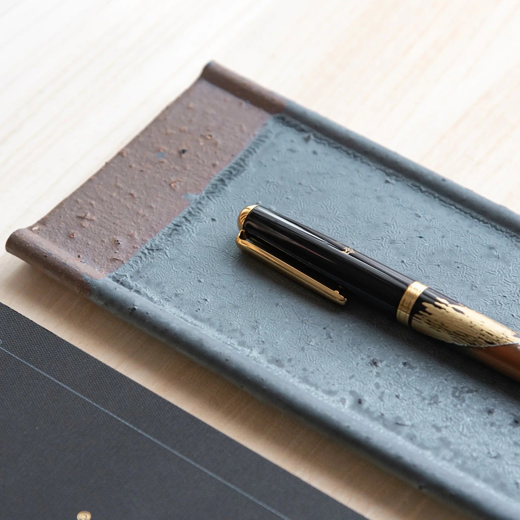 Japanese Pen Tray Desk Accessory, silver-gray ceramic tray with fountain pen placed diagonally and notebook.