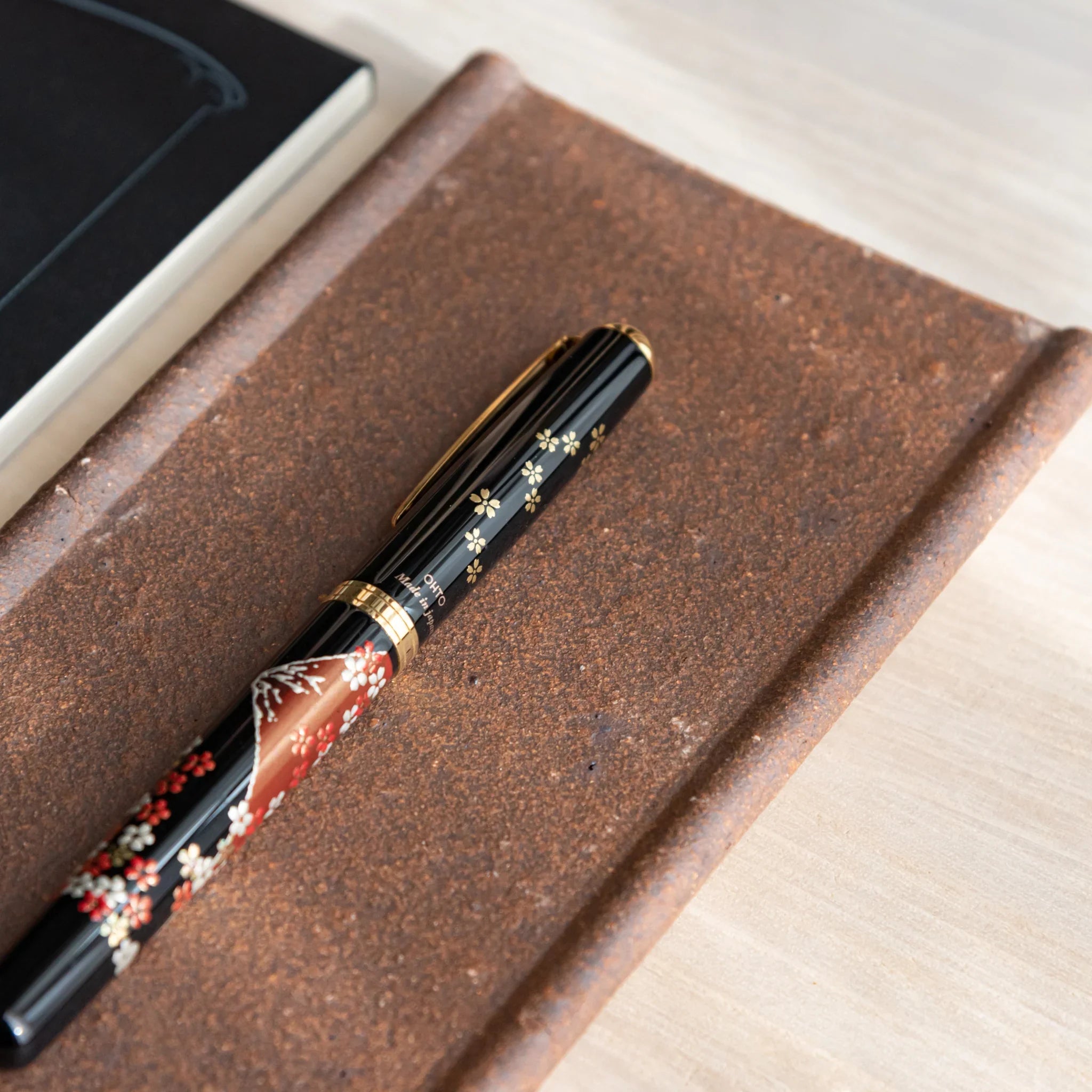 Japanese Pen Tray Desk Accessory, yakishime clay ceramic tray with fountain pen placed diagonally and notebook.