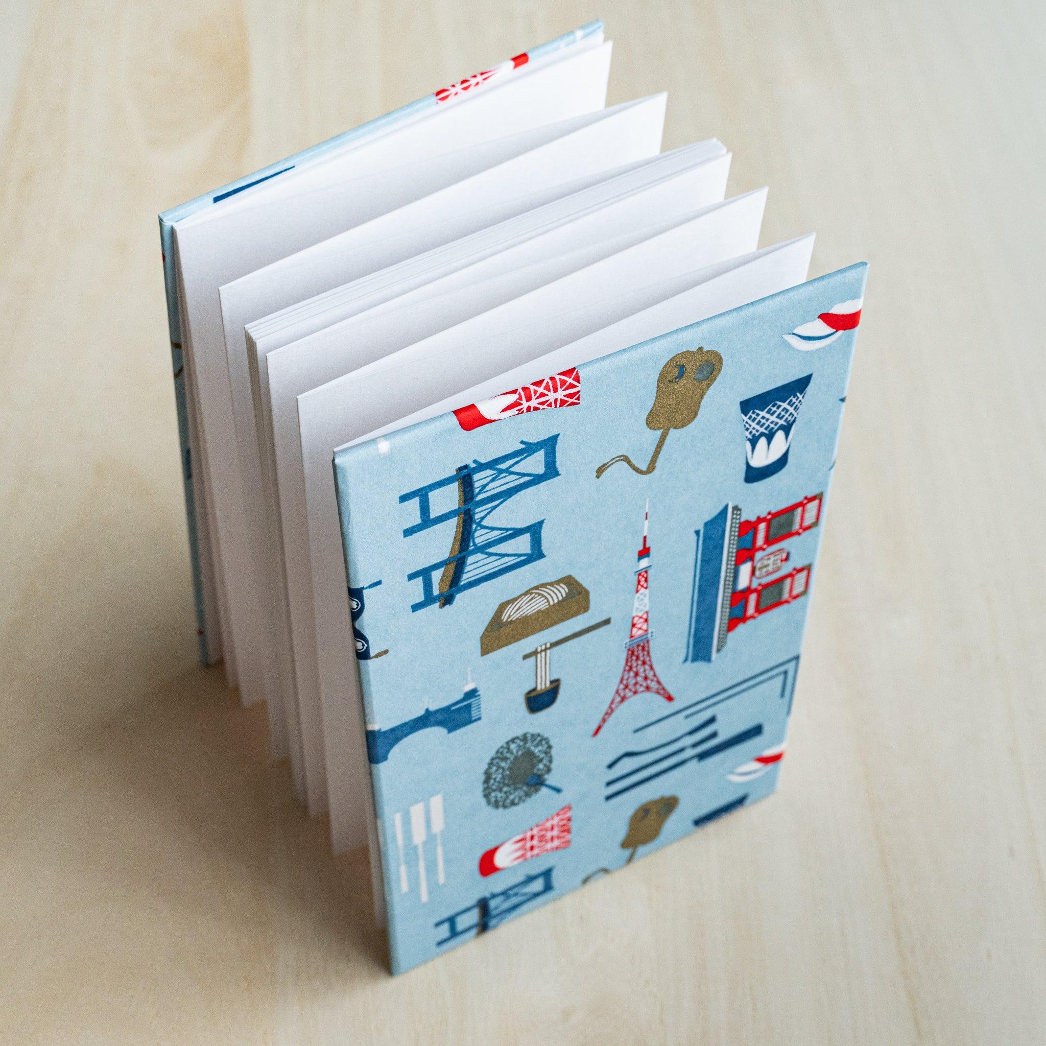 Edo Tokyo goshuincho stamp book standing open, accordion-fold white pages fanned out, light blue cover