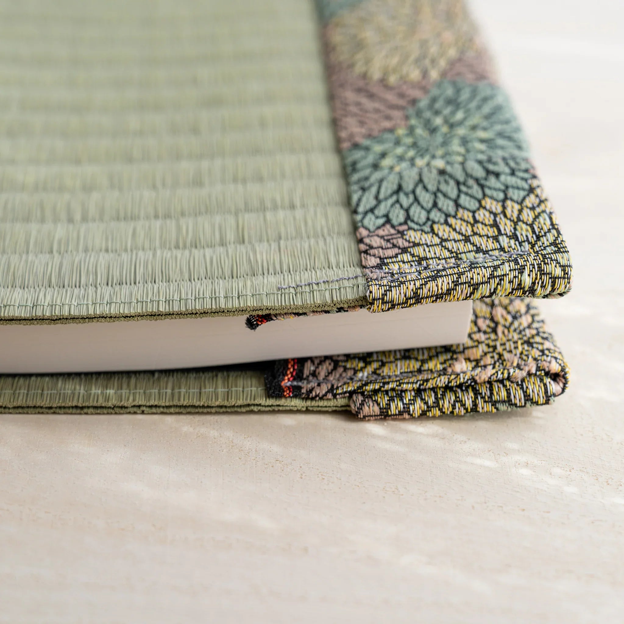 Side view of tatami book cover with notebook inserted, showing thickness and folded chrysanthemum patterned flap