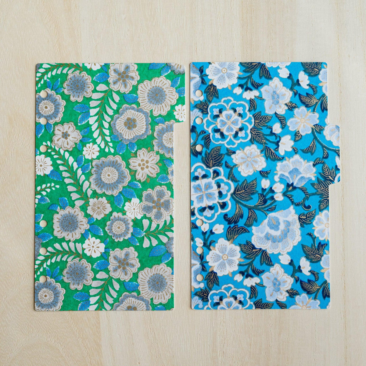 Two Garden index dividers side by side, green with grey-blue flowers and bright blue with white flowers