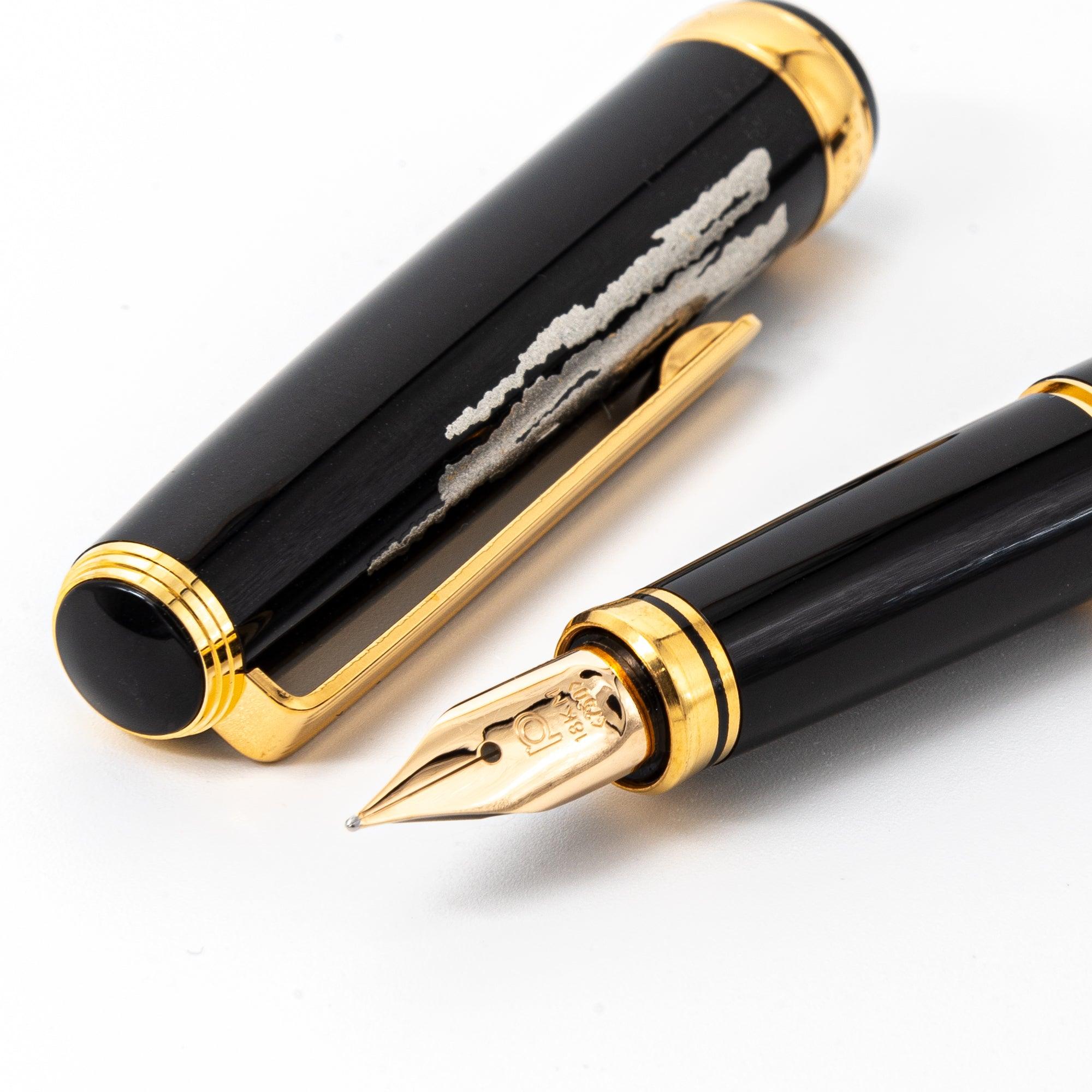 Close-up of the Mt. Fuji maki-e Japanese fountain pen, featuring a gold nib and intricate silver accents on a black lacquered cap.