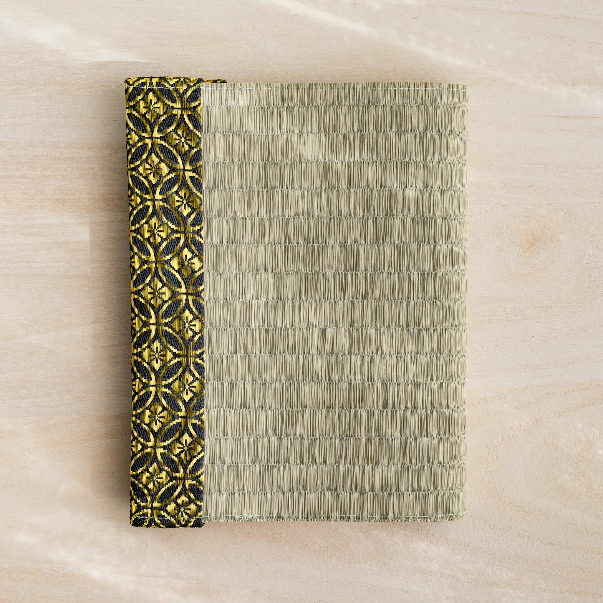 Gold Shippo tatami book cover closed, woven green rush straw with black and gold Japanese shippo circle band at left