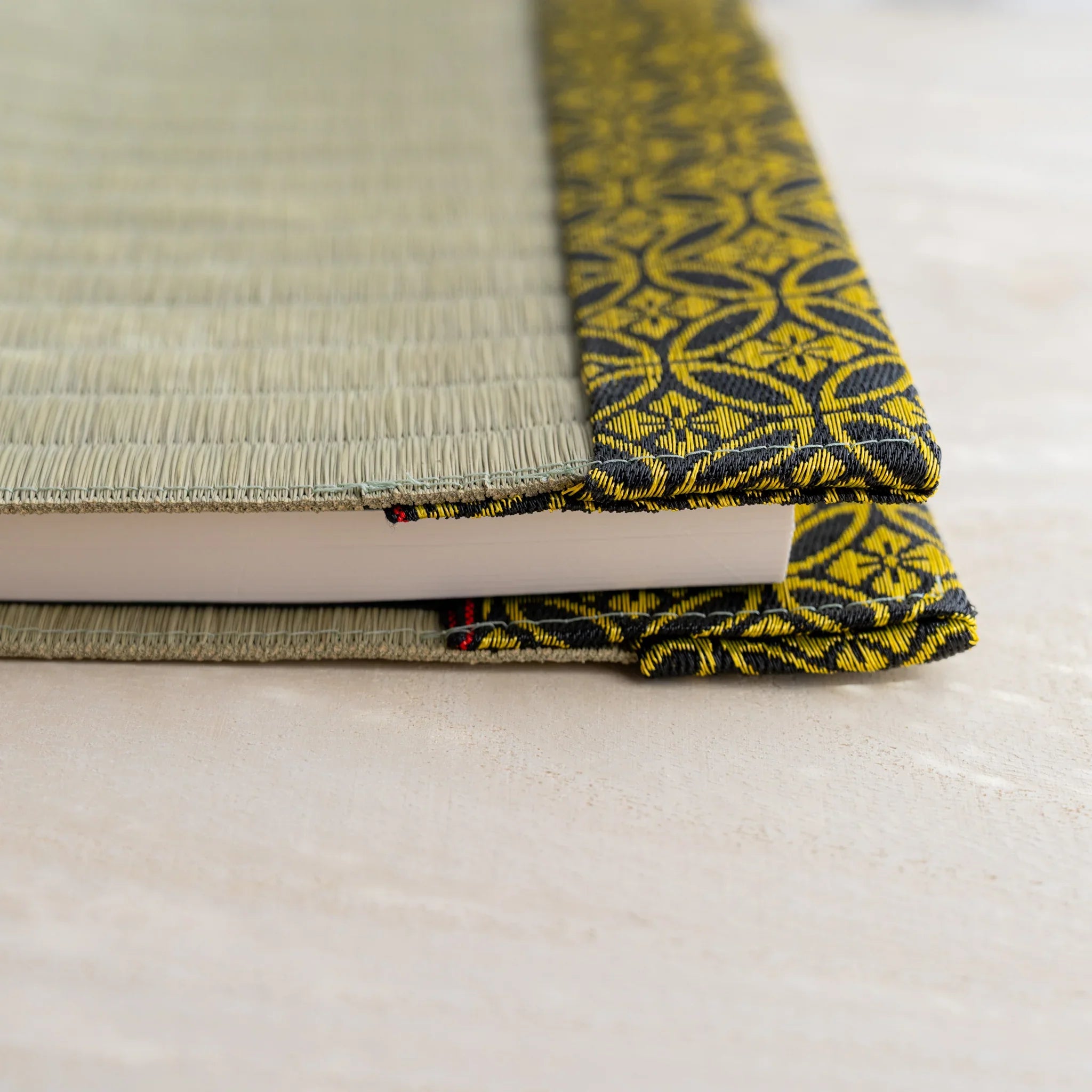 Side view of Gold Shippo tatami book cover with notebook inserted, showing thickness and folded patterned flap
